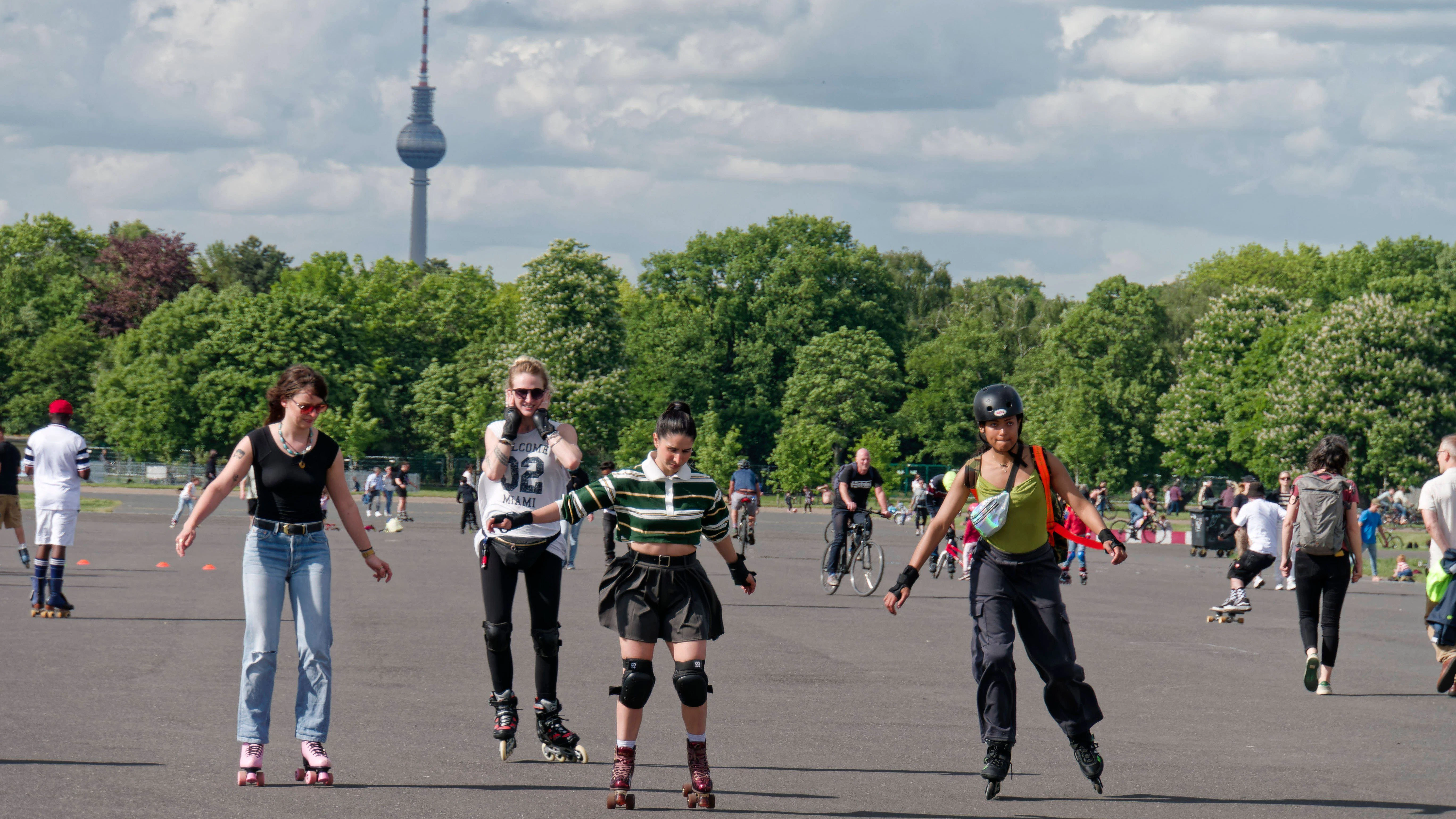Fröhliche Menschen haben Spaß in Berlin. Im Hintergrund steht der Fernsehturm.