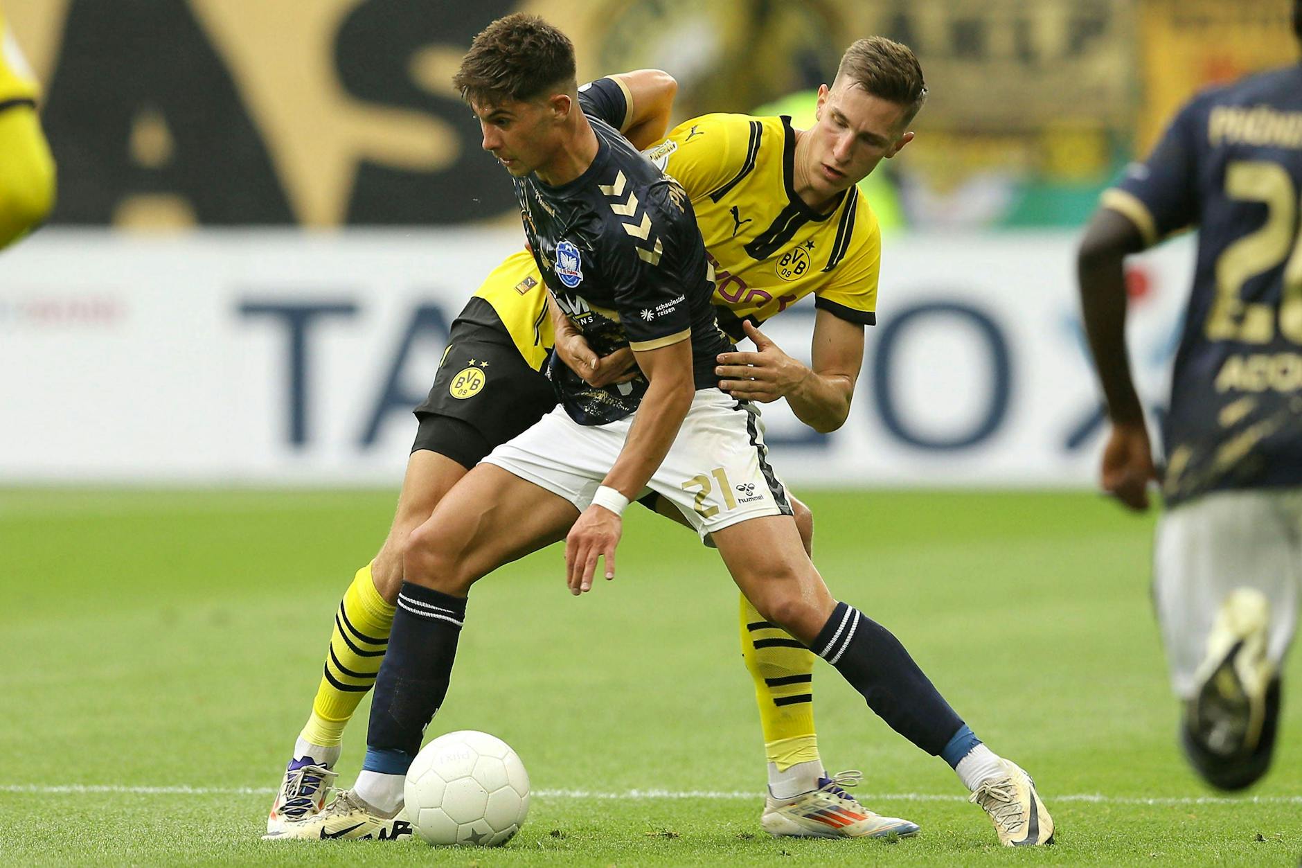 In der ersten Runde des DFB-Pokals 2024/25 war Valdemar Sadrifar (l.) mit Lübeck gegen Borussia Dortmund und Nico Schlotterbeck am Start.