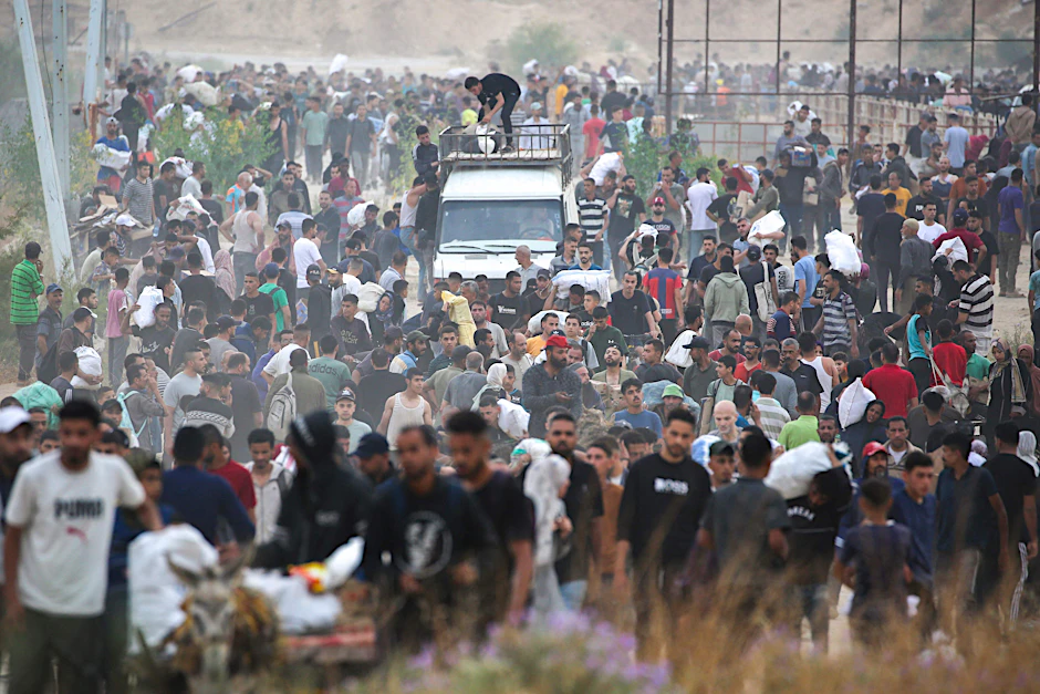 Menschen tragen Hilfsgüter der Gaza Humanitarian Foundation (GHF)