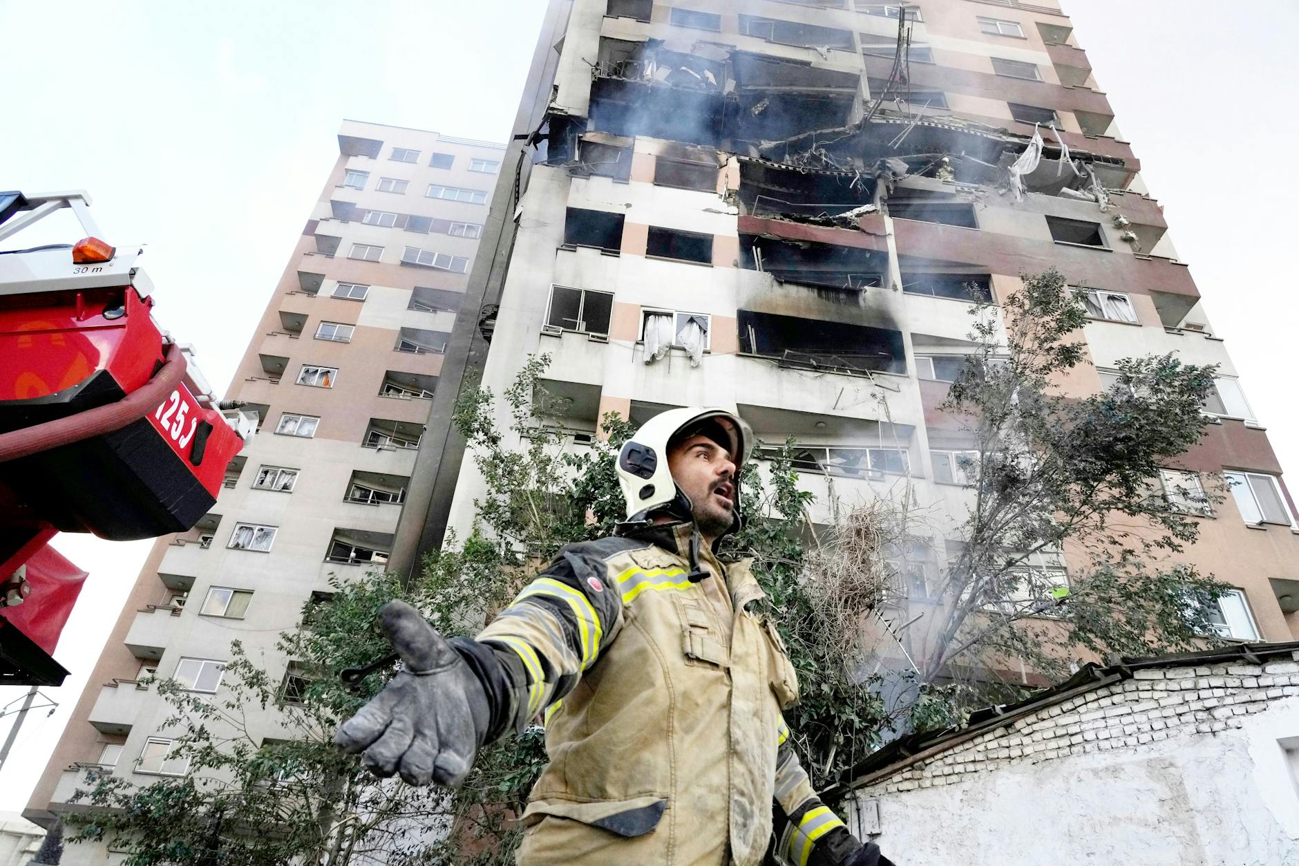 Iran, Teheran: Ein Feuerwehrmann ist am Ort einer Explosion in einer Wohnanlage im Einsatz.