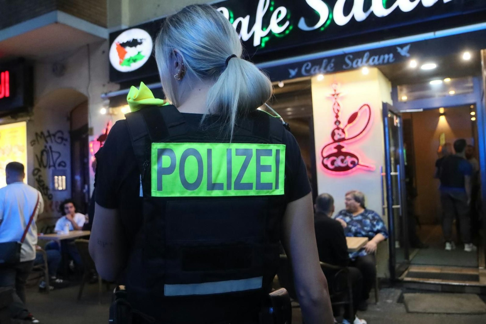 Eine Polizeibeamtin sichert bei der Großrazzia in Neukölln gegen Clans einen Lokaleingang.