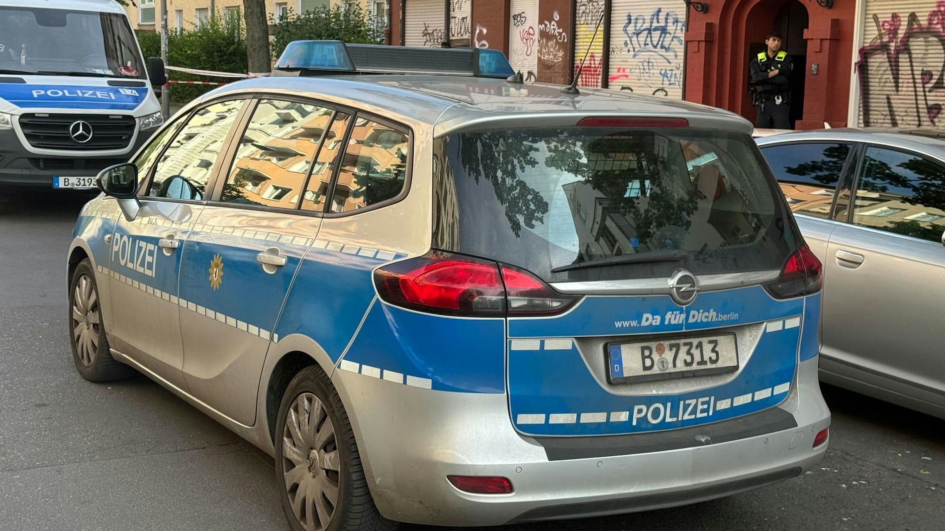Einsatzfahrzeuge der Polizei stehen am Tatort. Über ein geparktes Auto erhoffen sich die Ermittler entscheidende Hinweise zur Tat.