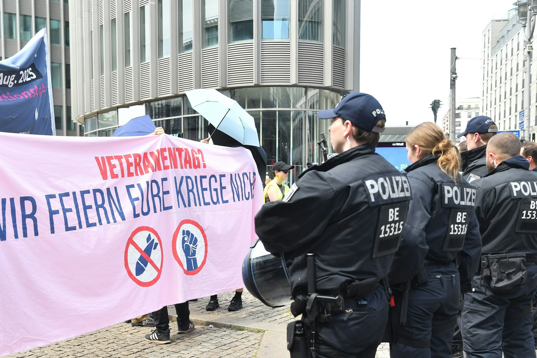 Am ersten Nationalen Veteranentag protestieren am Bahnhof Friedrichstraße Menschen gegen die bundesweit stattfindende Veranstaltung.