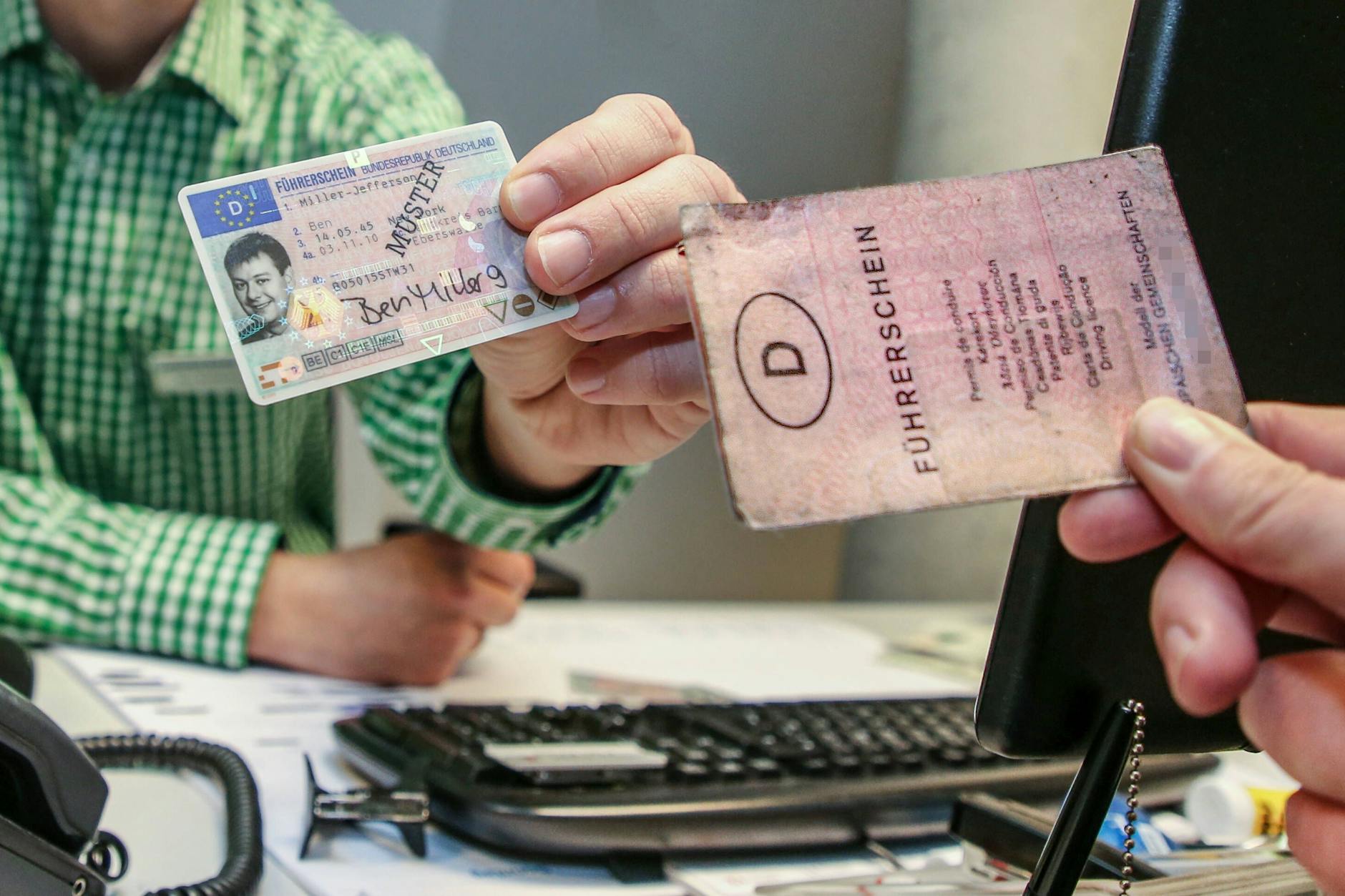 Ein alter Papierführerschein und ein neuer Muster-EU-Führerschein im Scheckkartenformat