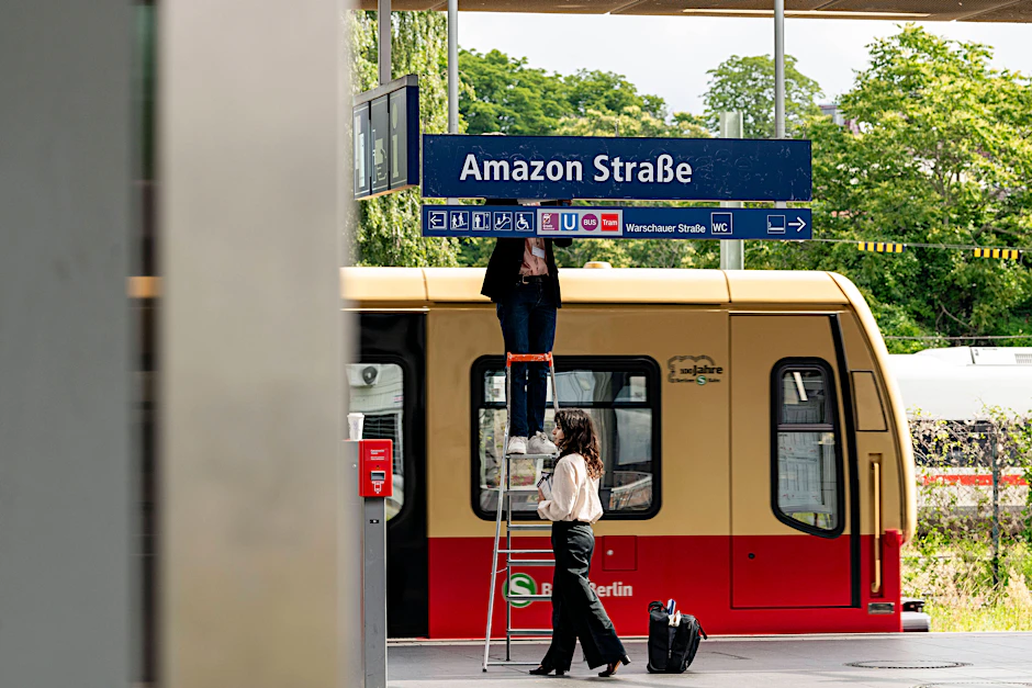 Die Berliner Künstler Jakob Wirth und Marina Resende überkleben das S-Bahn-Schild als Protest gegen den Amazon-Standort in Berlin.