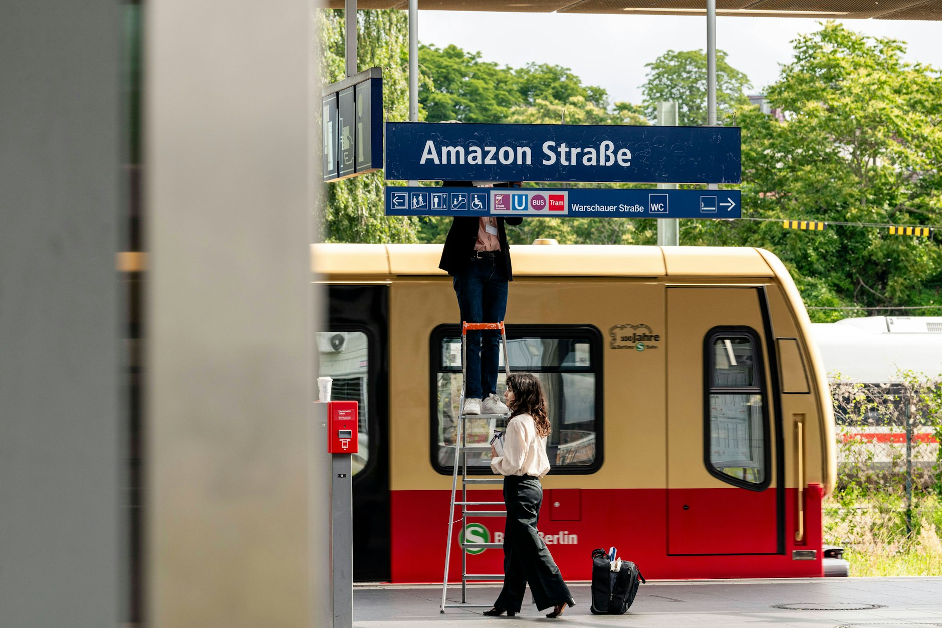 Die Berliner Künstler Jakob Wirth und Marina Resende überkleben das S-Bahn-Schild als Protest gegen den Amazon-Standort in Berlin.