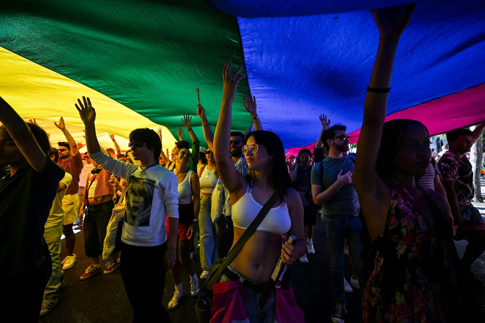Demonstranten unter einer Pride-Flagge