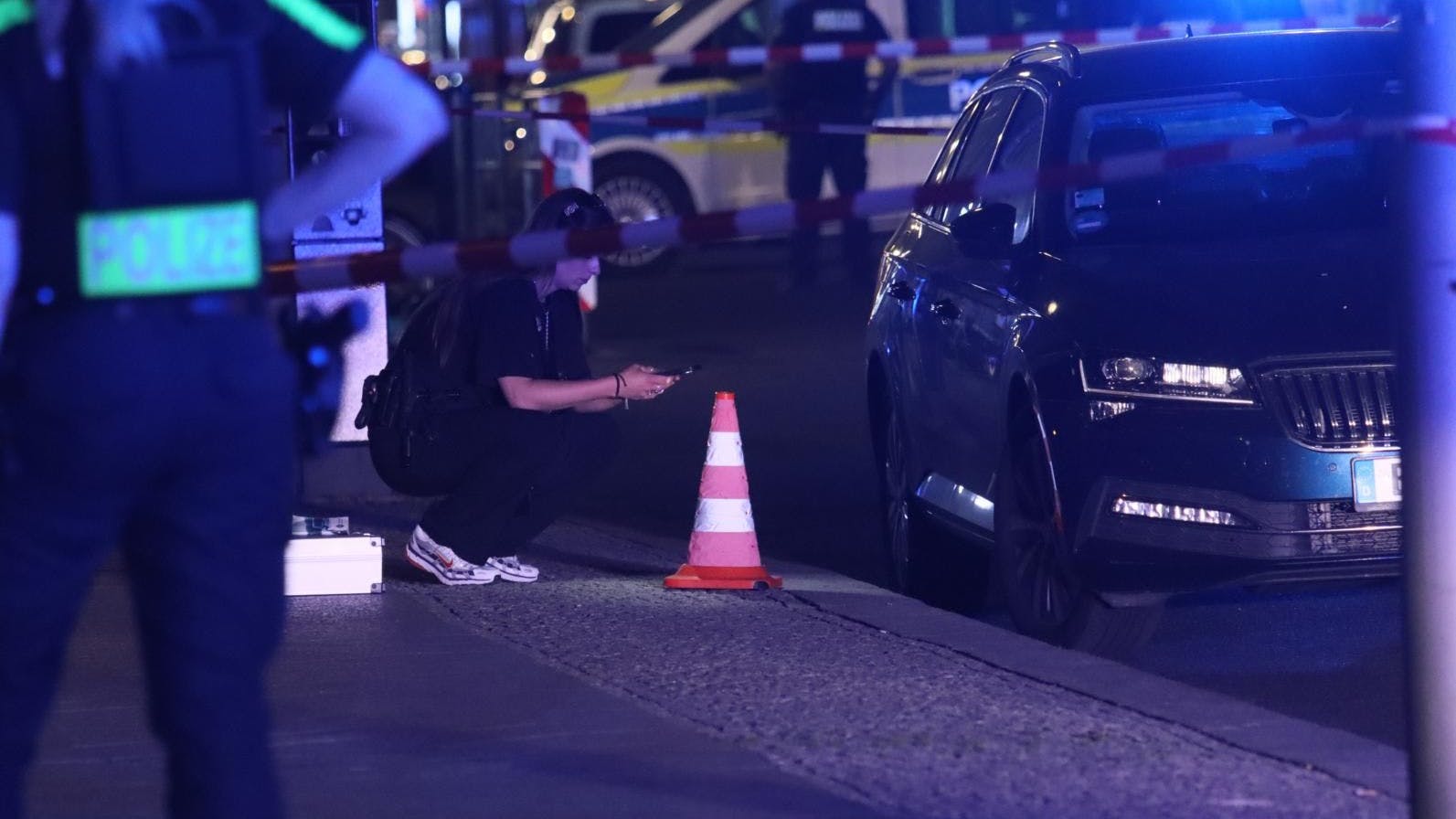 Beamte der Spurensicherung untersuchten Spuren an und unter einem dunklen Skoda.