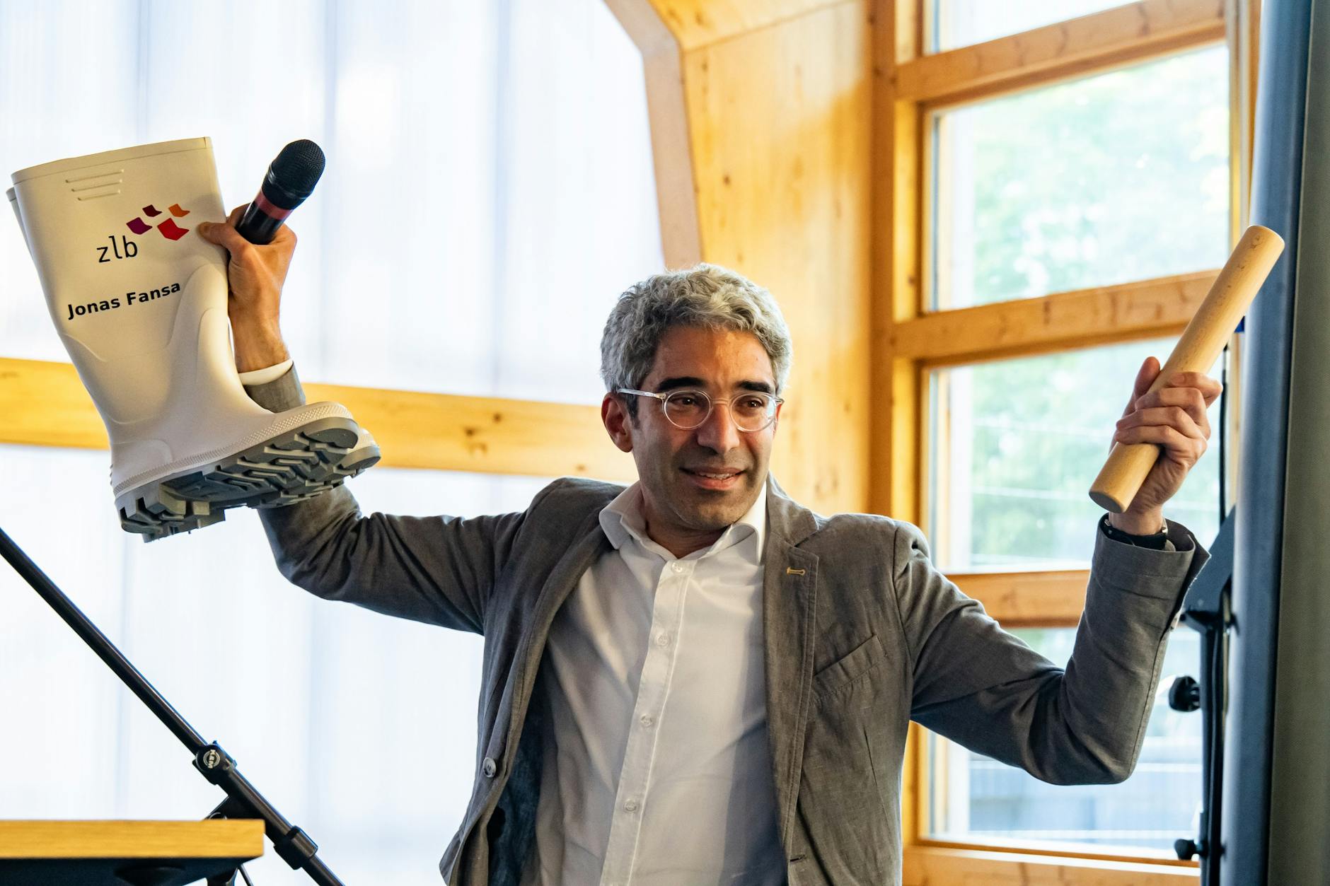 Der neue Generaldirektor der Berliner Zentral- und Landesbibliothek, Jonas Fansa, mit Gummistiefeln und Staffelstab im Pop-up-Bau der Amerika-Gedenkbibliothek am Dienstagabend.