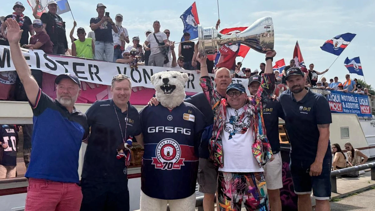 Gruppenbild der honorigen Feier-Biester: (v. l.) Marco Ackermann von Liqui Moly, Eisbäen-Geschäftsführer Thomas Bothstede, Maskottchen Bully, der Fanbeauftragter Holli Wende,&nbsp; „Eisbären Helfen Eisbären e.V.“-Chef Peter Breitenberg mit Meisterpokal sowie die Verteidiger Eric Mik (leicht verdeckt) und Marco Nowak.