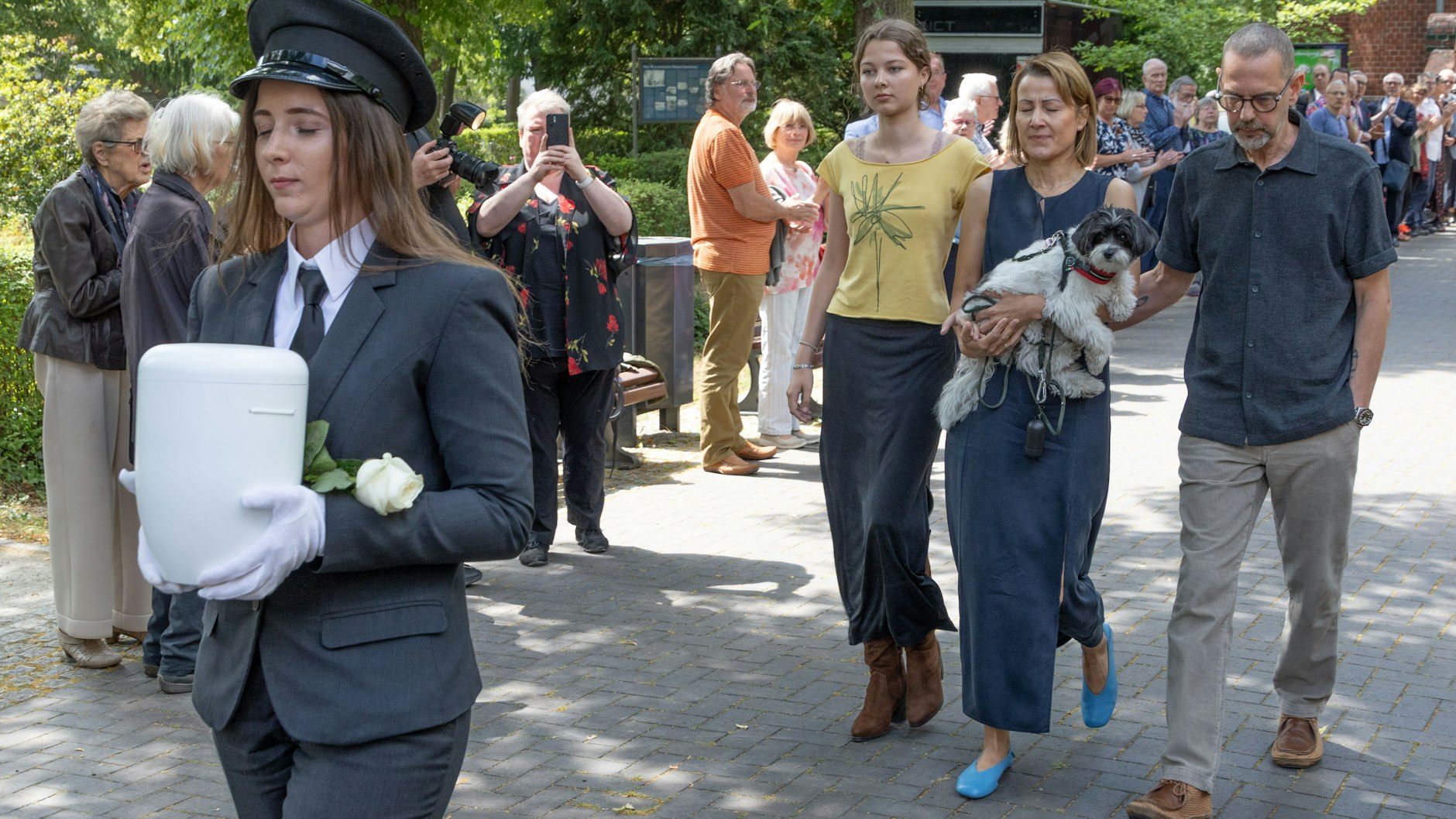 Hinter der Urne von Urte Blankenstein laufen Sohn Mathias, dessen Frau Alex und die Enkelin Clara Rosa