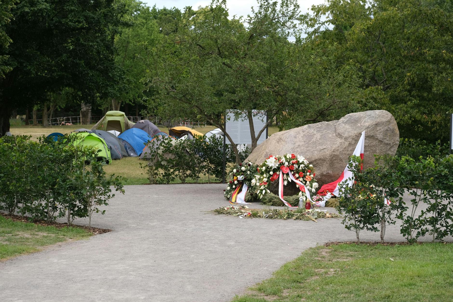 Der Gedenkstein für polnische Opfer des Zweiten Weltkrieges. Daneben ist das Camp der Palästina-Anhänger.