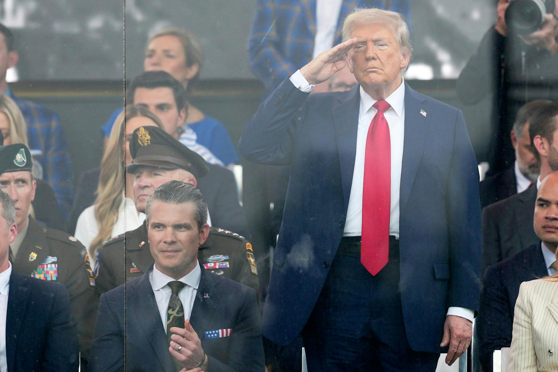 US-Präsident Donald Trump (M) salutiert neben seinem Verteidigungsminister Pete Hegseth (l) während der Militärparade zu Trumps Geburtstag.