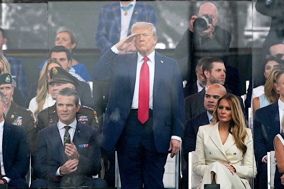 US-Präsident Donald Trump (M) salutiert neben seinem Verteidigungsminister Pete Hegseth (l) während der Militärparade zu Trumps Geburtstag.
