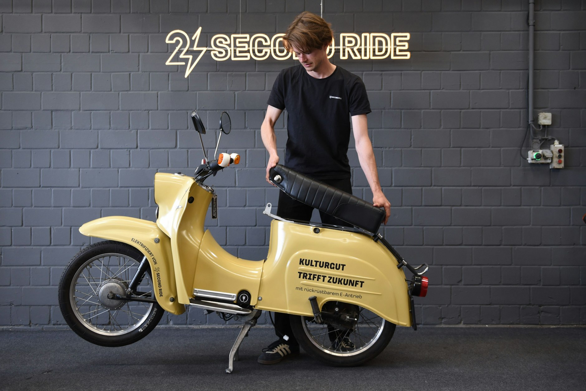 Second-Rider-Gründer Carlo Schmid nimmt die Sitzbank von dieser Schwalbe ab: Darin steckt der Akku. Der lässt sich an jeder Steckdose aufladen.