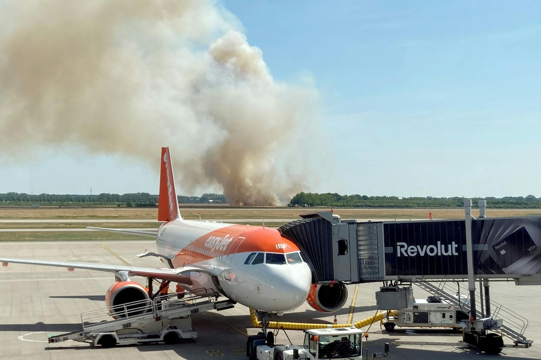Dichter Rauch steigt beim Brand auf einem Getreidefeld im Ortsteil Waltersdorf unweit des Flughafens BER auf.
