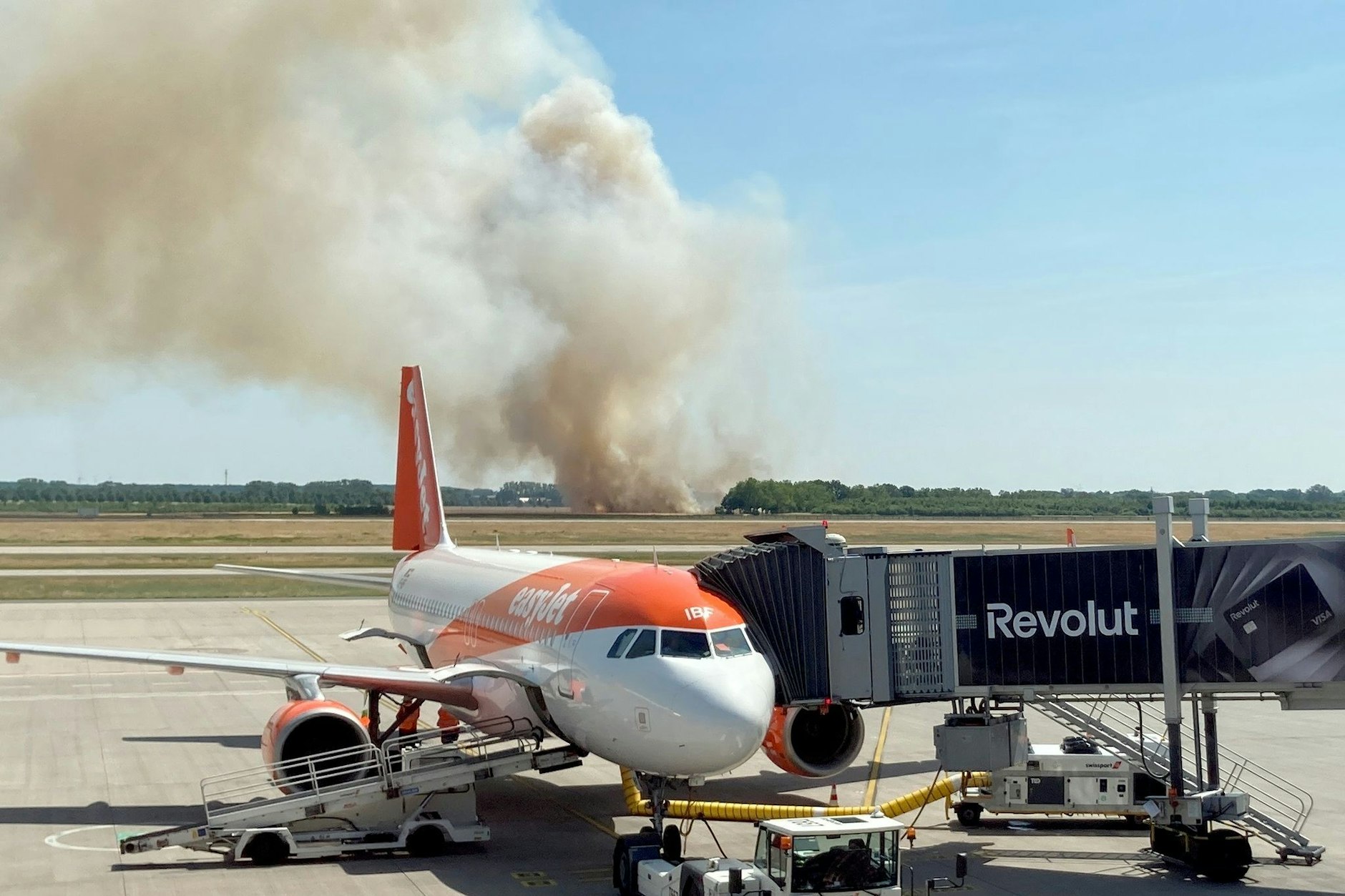 Dichter Rauch steigt beim Brand auf einem Getreidefeld im Ortsteil Waltersdorf unweit des Flughafens BER auf.
