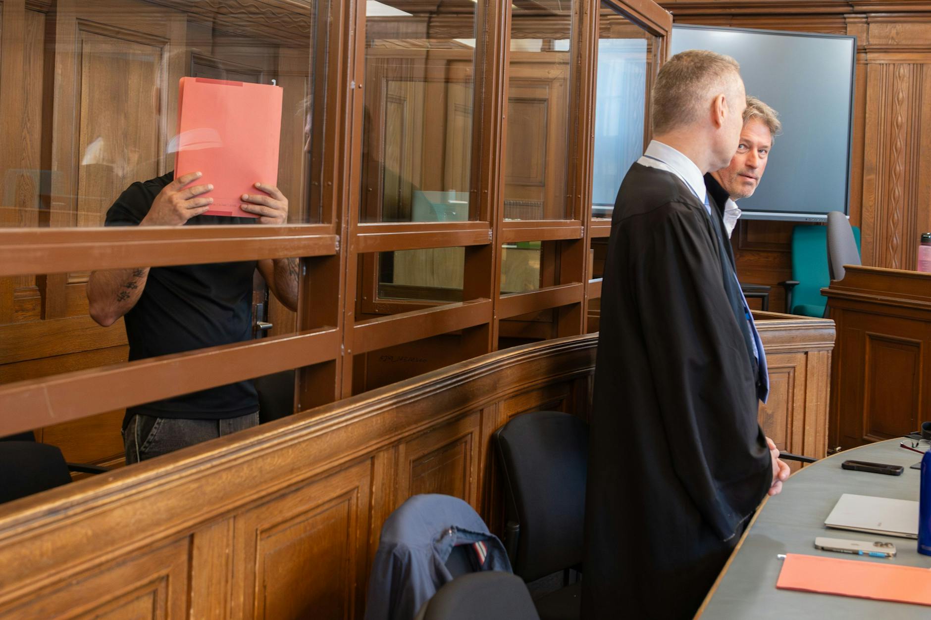 Der Angeklagte Gheorghe R. verbirgt im Gerichtssaal sein Gesicht vor den Fotografen.