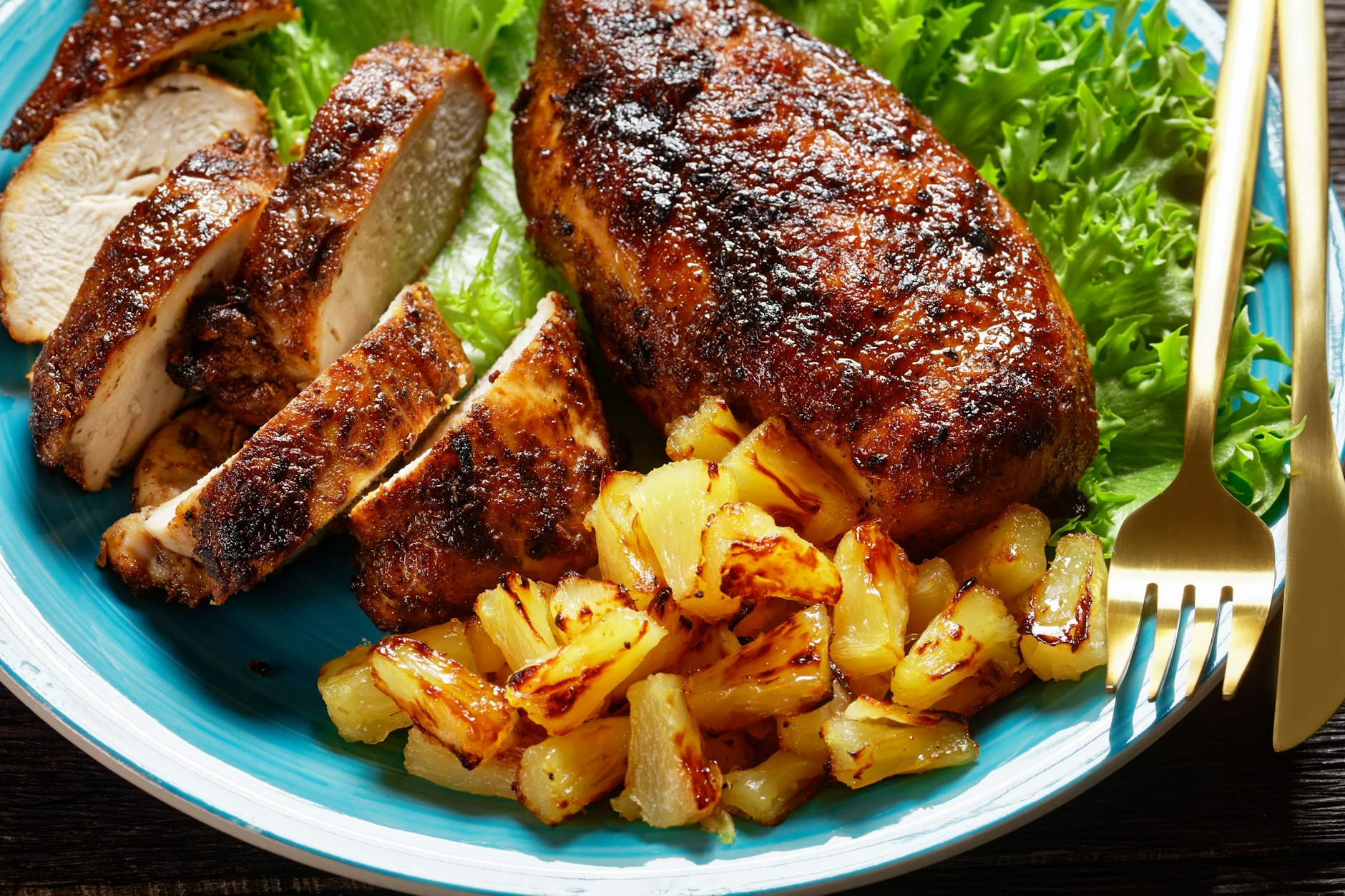 Die einfache Variante: Das Brathähnchen mit zusammen mit gebratener Ananas, angerichtet auf grünem Salat, serviert.