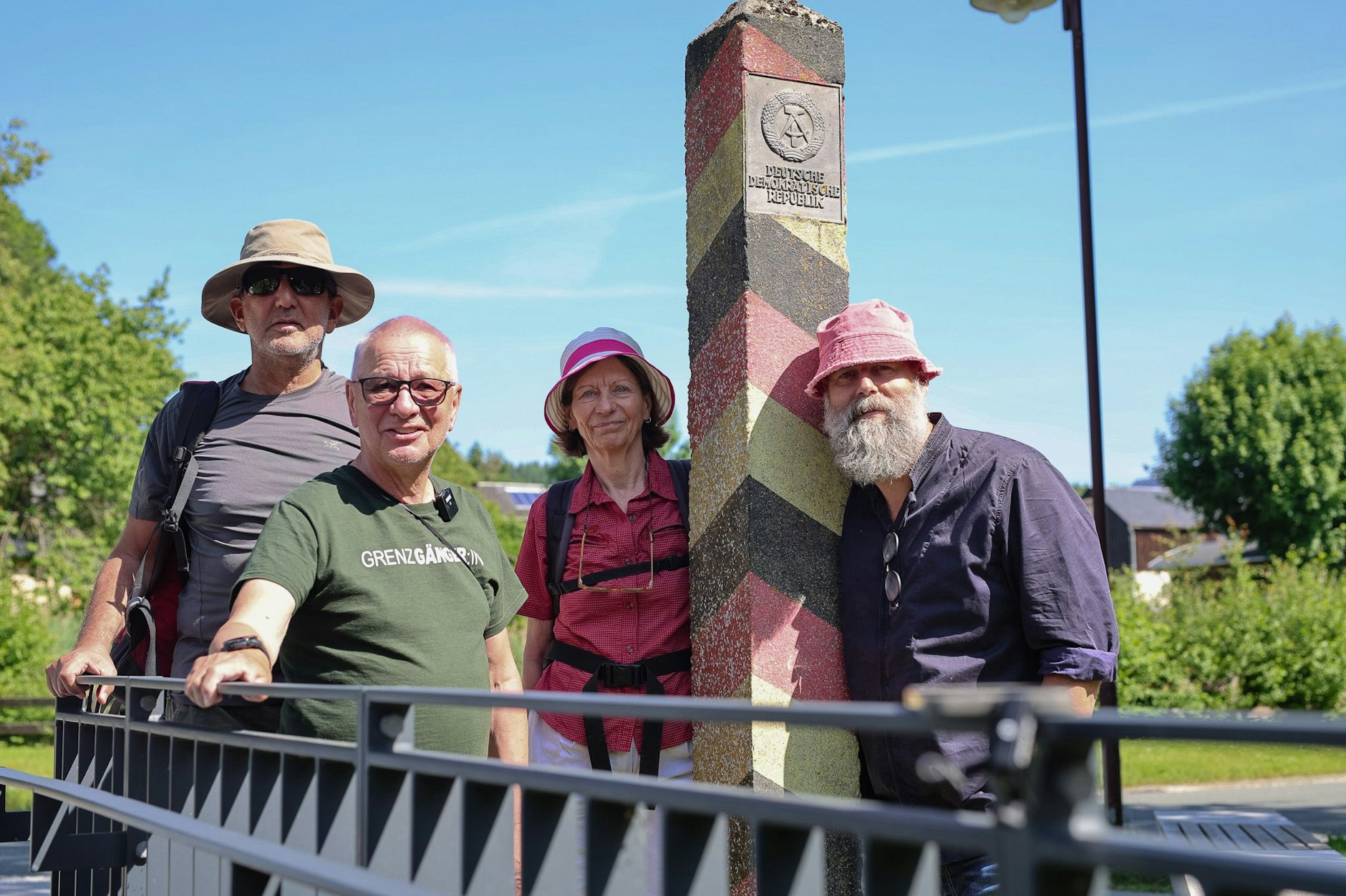 Günter Polauke und seine zeitweilige Begleitung an einem Pfahl, der einst im thüringischen Mödlareuth die Staatsgrenze DDR-BRD markierte. V.l.n.r: Heskel Nathaniel, Günter Polauke, Maritta Tkalec, Holger Friedrich.