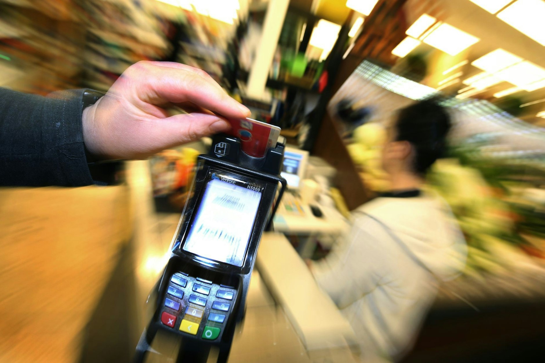 Eine Bezahlkarte wird in den Bezahlterminal an der Kasse eines Supermarktes geschoben.
