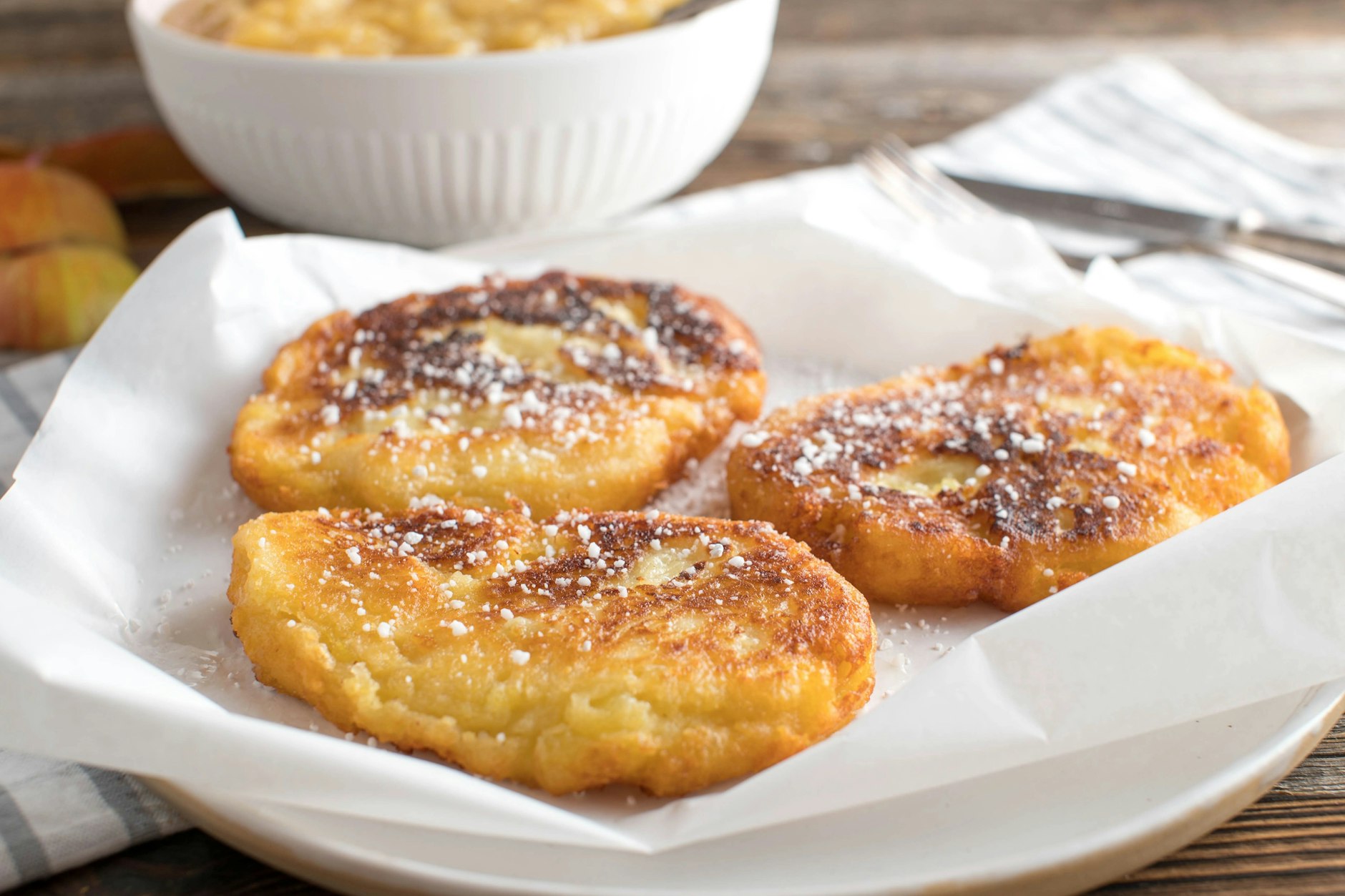 Mit Puderzucker bestreute sächsische Quarkkeulchen passen perfekt zu Apfelmus.