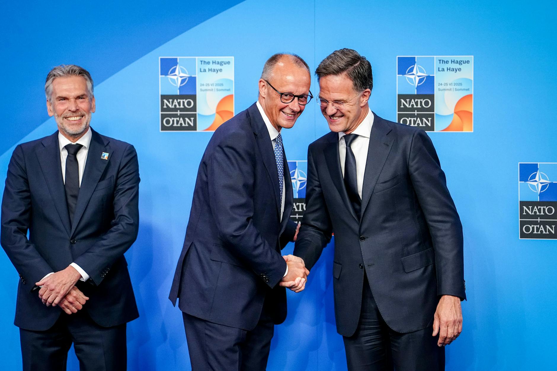 Bundeskanzler Friedrich Merz wird von Mark Rutte, Generalsekretär der Nato, und Dick Schoof (l.), Ministerpräsident der Niederlande, beim Nato-Gipfel empfangen.