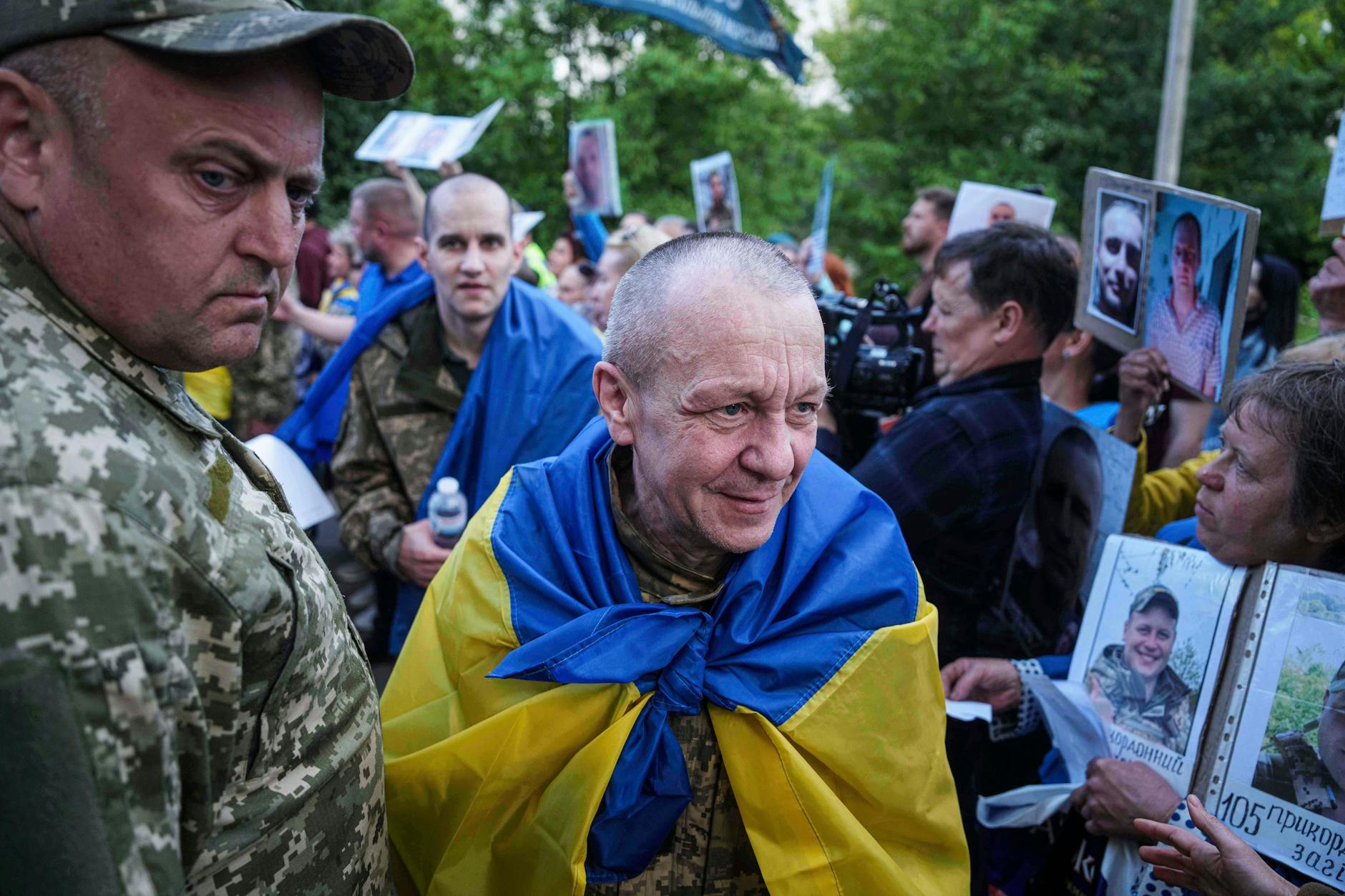 Vom Krieg gezeichnet: Freigelassene ukrainische Soldaten gehen durch ein Spalier von Menschen mit Fotos vermisster Verwandter.