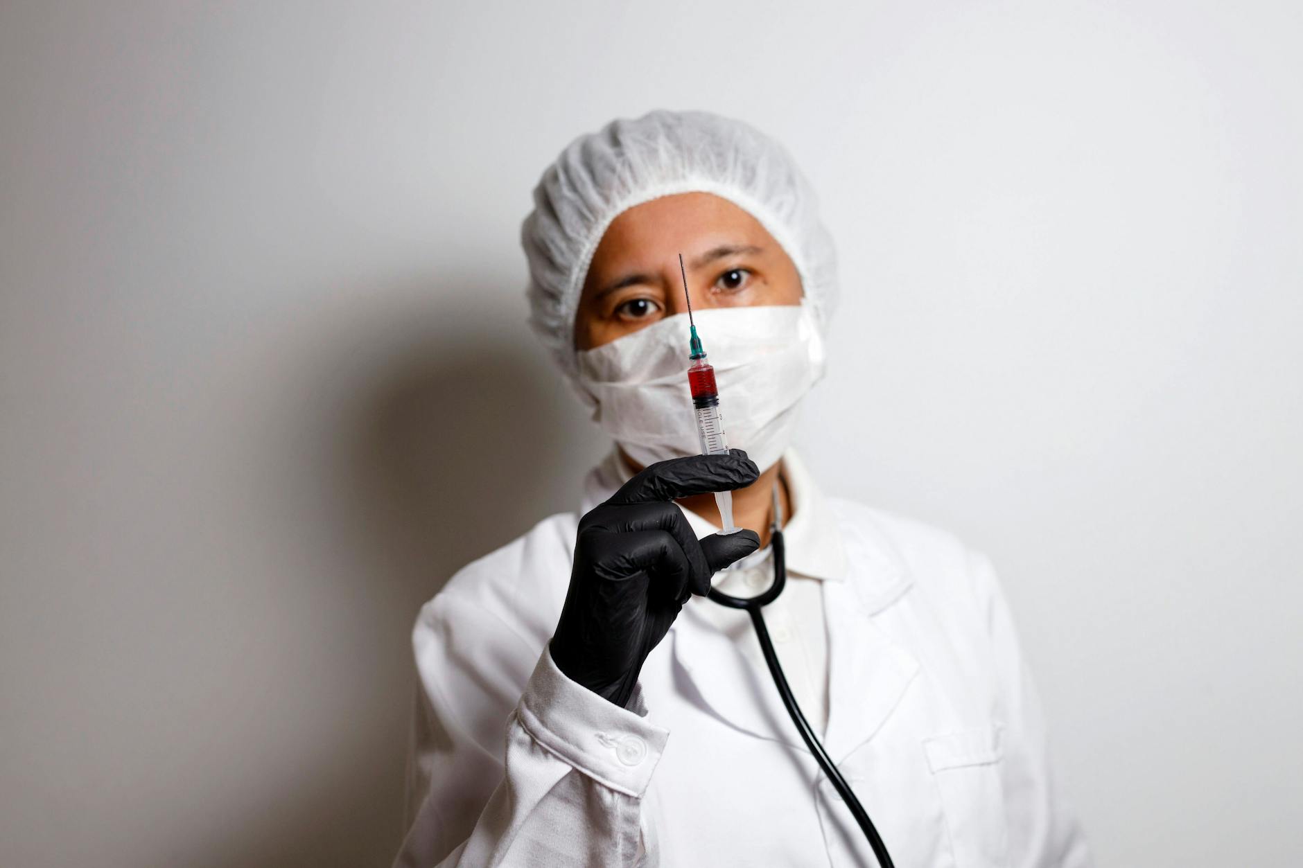 Eine Virologin posiert mit einer Spritze zur Impfung gegen das Coronavirus.