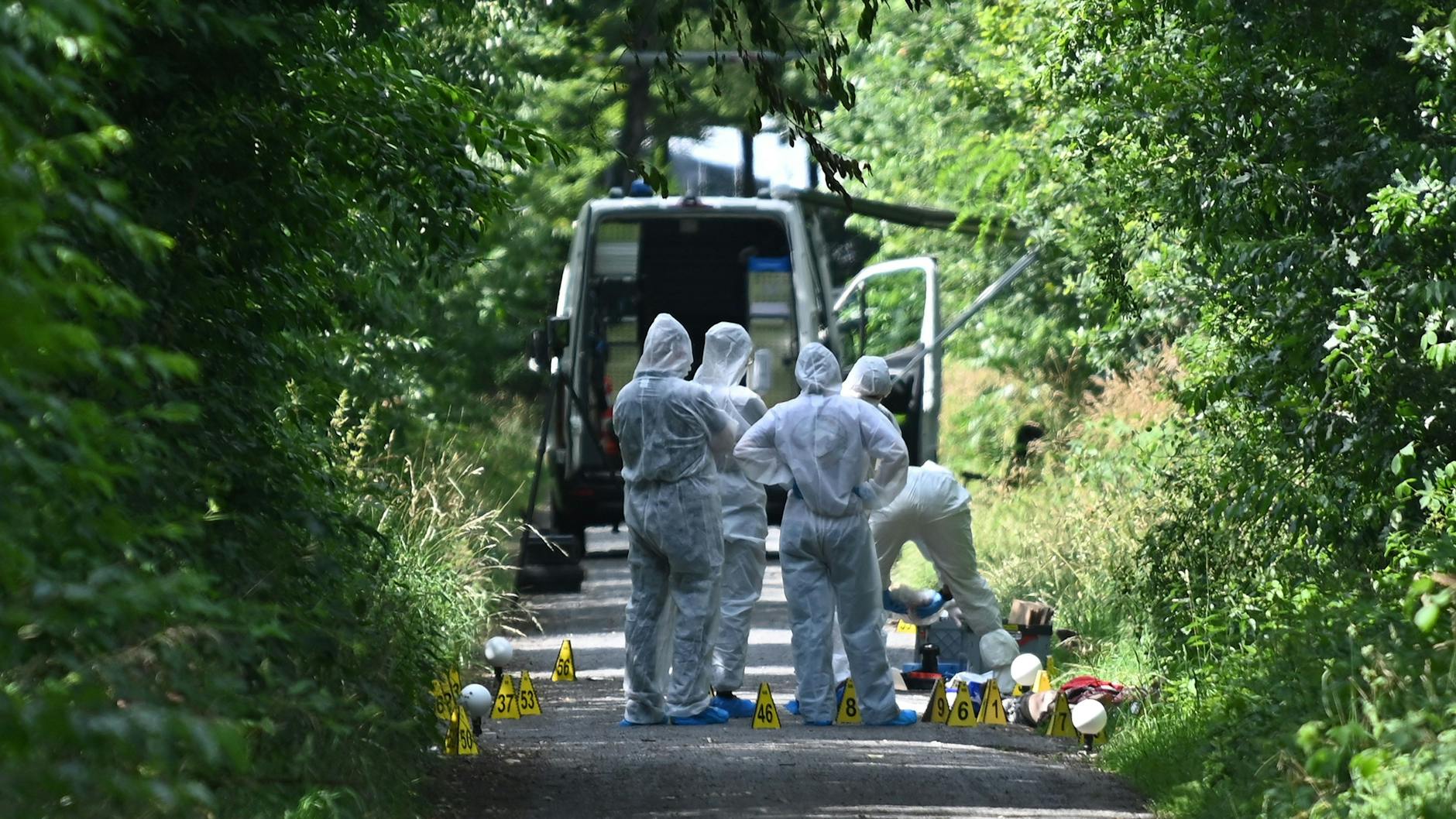 Ermittler stehen auf einem Waldweg in Dorsten (NRW). Die tote Frau wurde hier gefunden. Im Gebüsch lag ihr totes Kind.