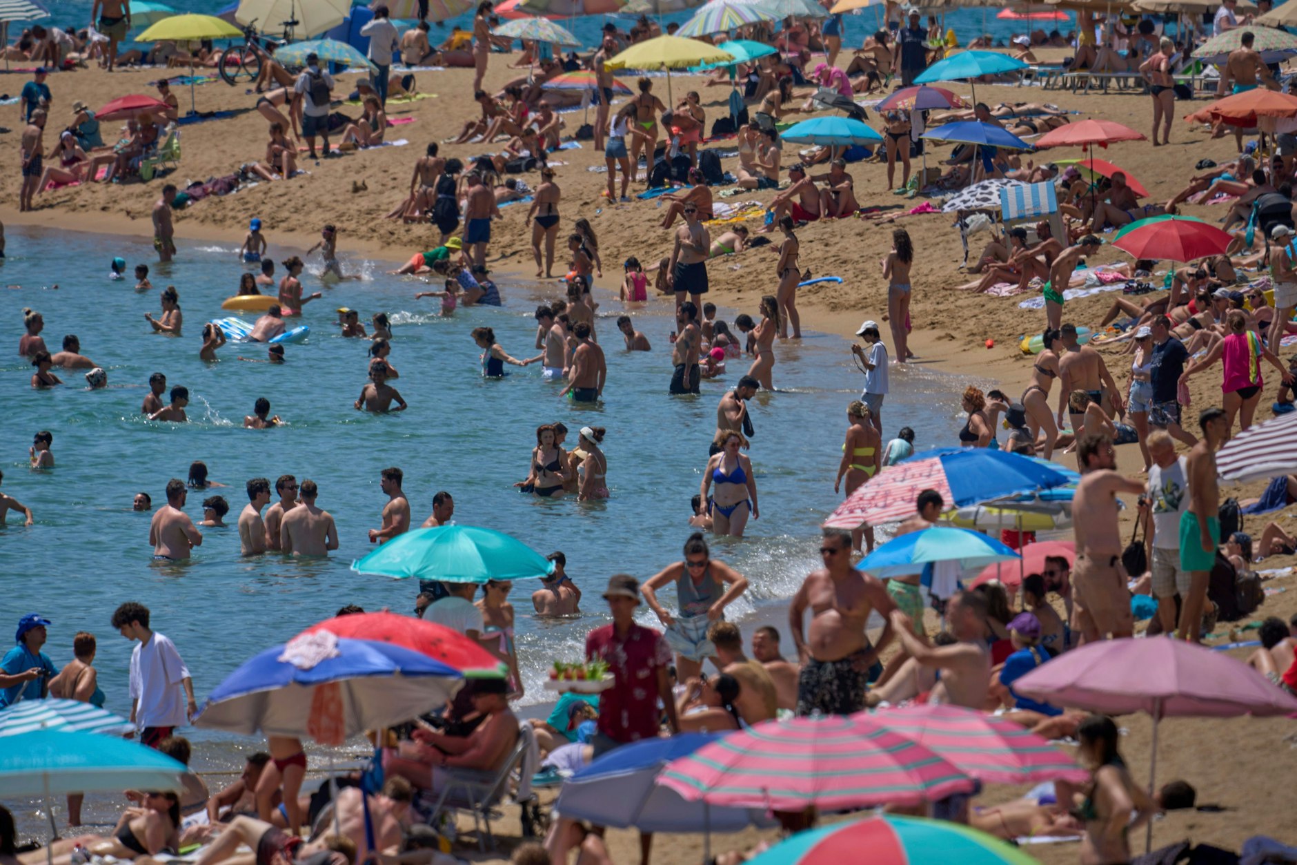 Barcelona: Besucher des Stadtstrandes kühlen sich im Wasser ab.