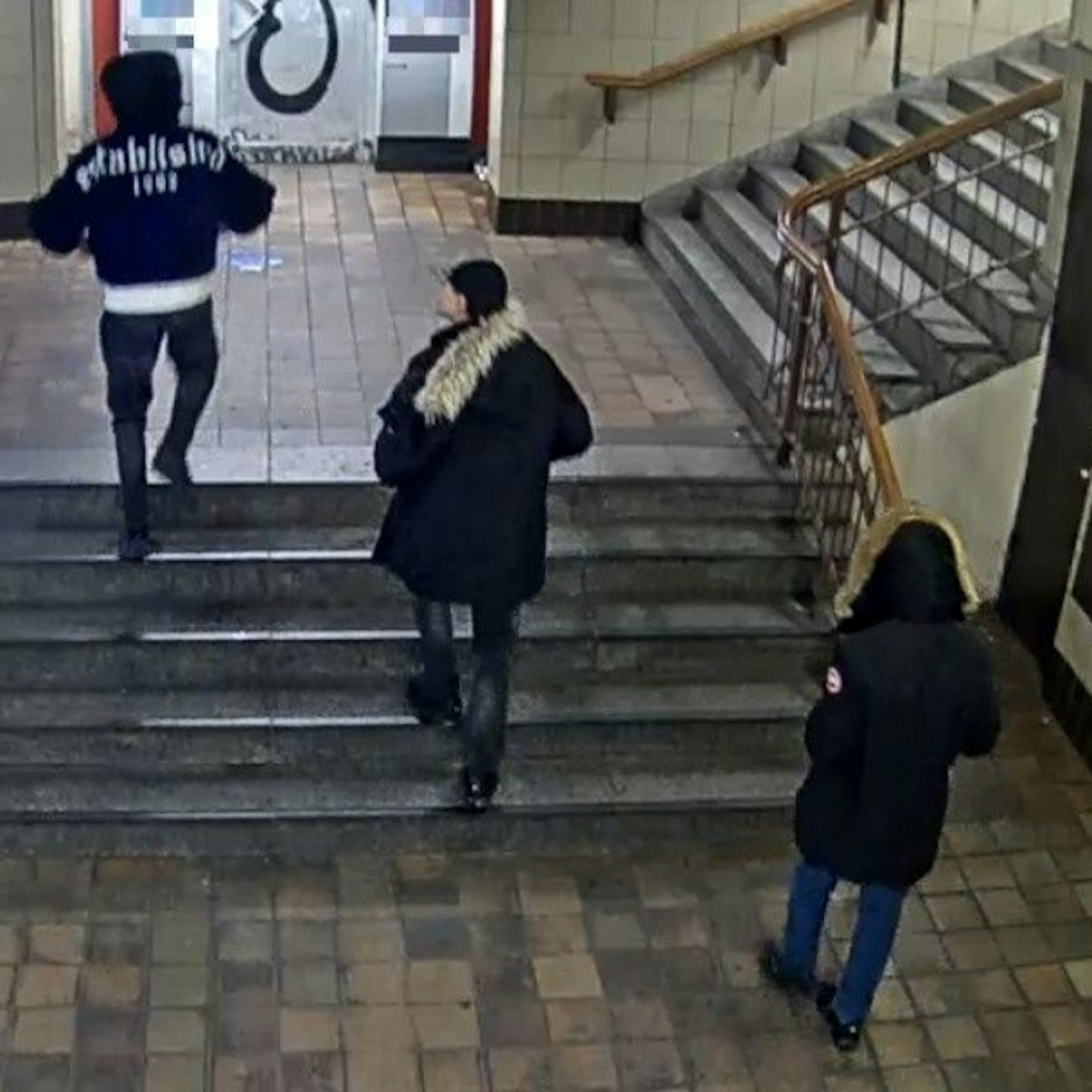Die drei Räuber im U-Bahnhof Schlesisches Tor. Von hinten erkennt man gut ihre auffälligen Jacken.