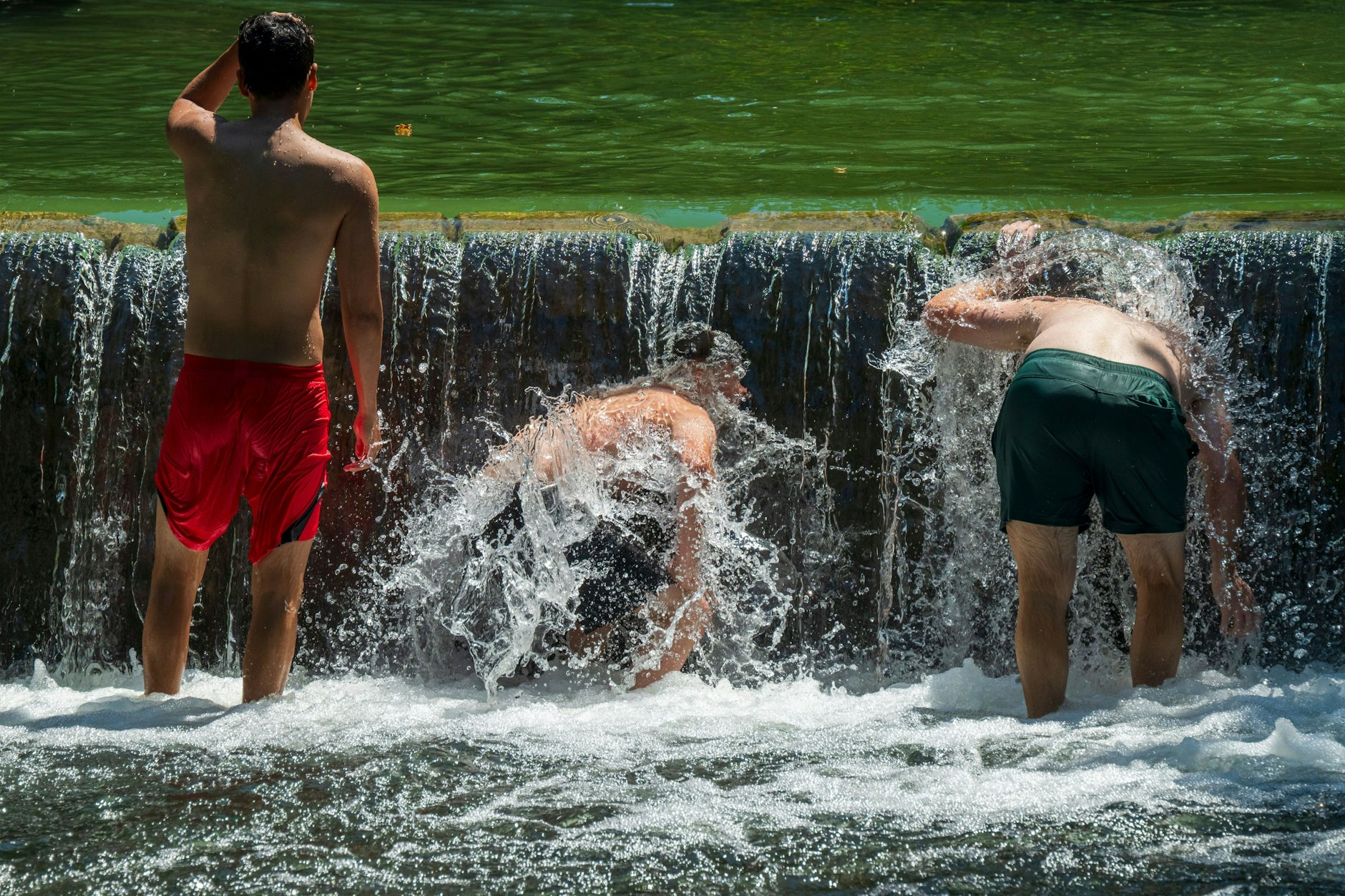 München: Jugendliche kühlen sich im Eisbach im Englischen Garten ab.