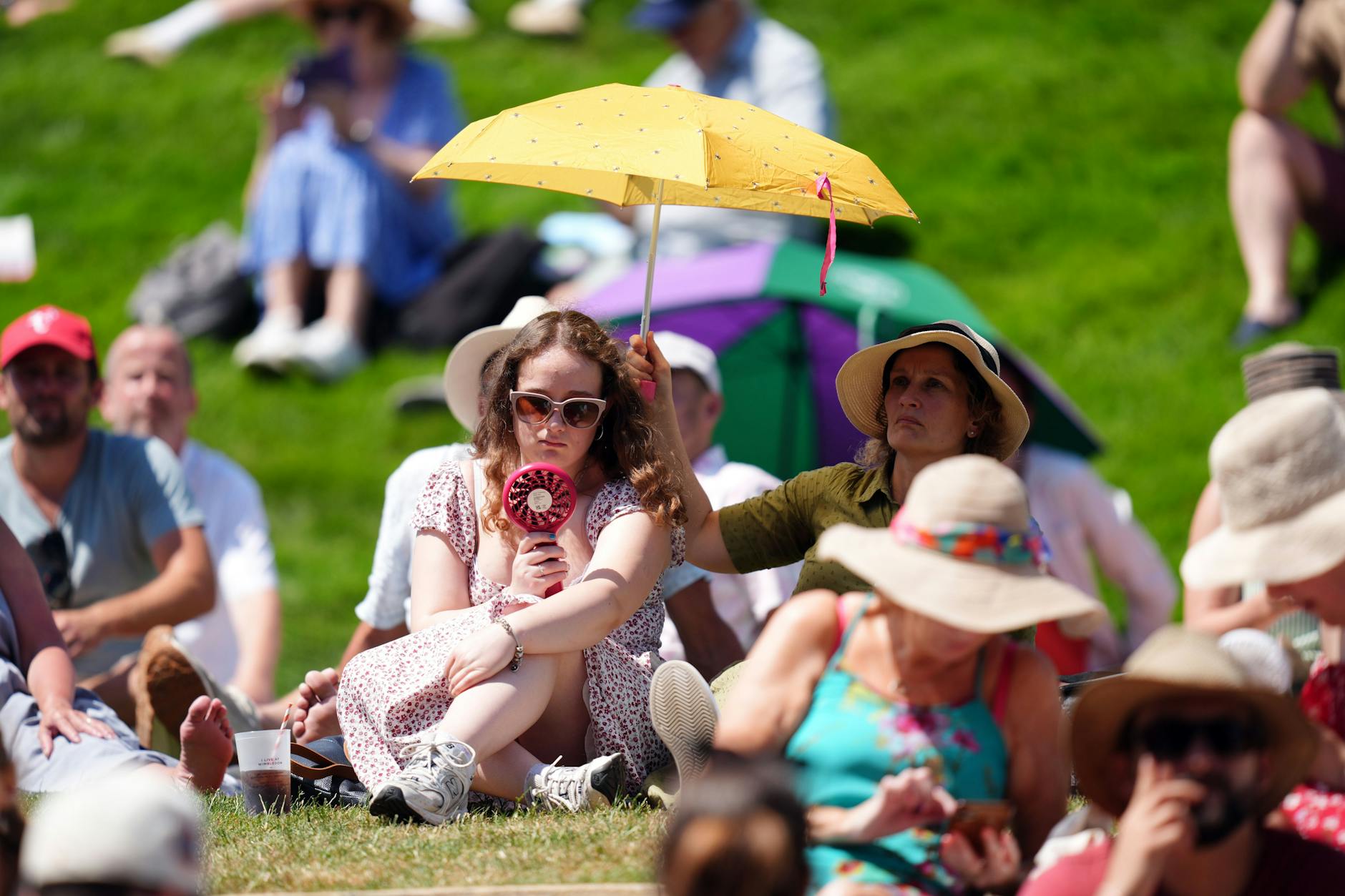 Grand-Slam-Turnier in Wimbledon 2025: Zuschauer auf dem Hügel schützen sich bei hohen Temperaturen vor der Sonne am ersten Tag der Wimbledon Championships 2025.