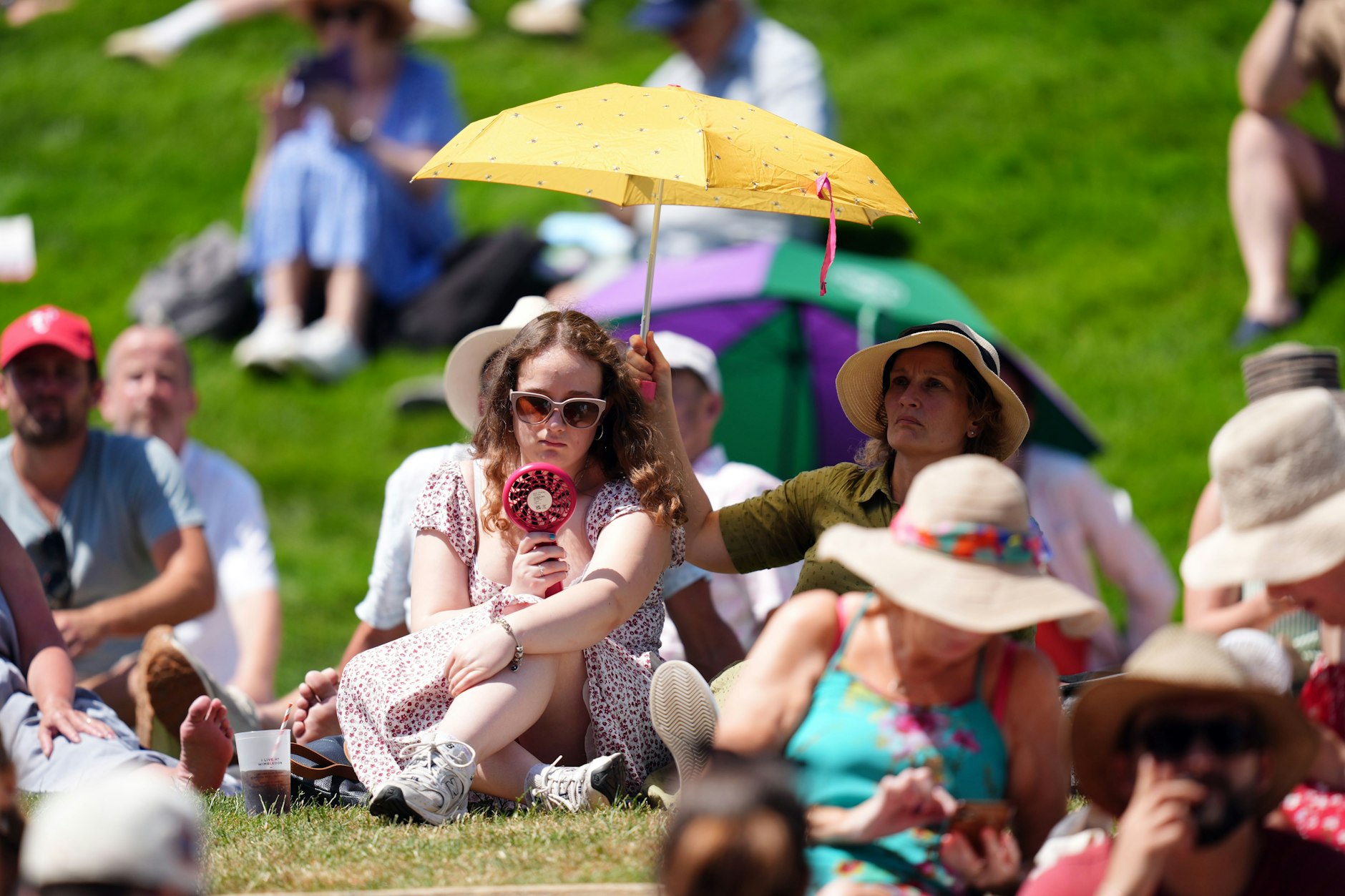 Grand-Slam-Turnier in Wimbledon 2025: Zuschauer auf dem Hügel schützen sich bei hohen Temperaturen vor der Sonne am ersten Tag der Wimbledon Championships 2025.