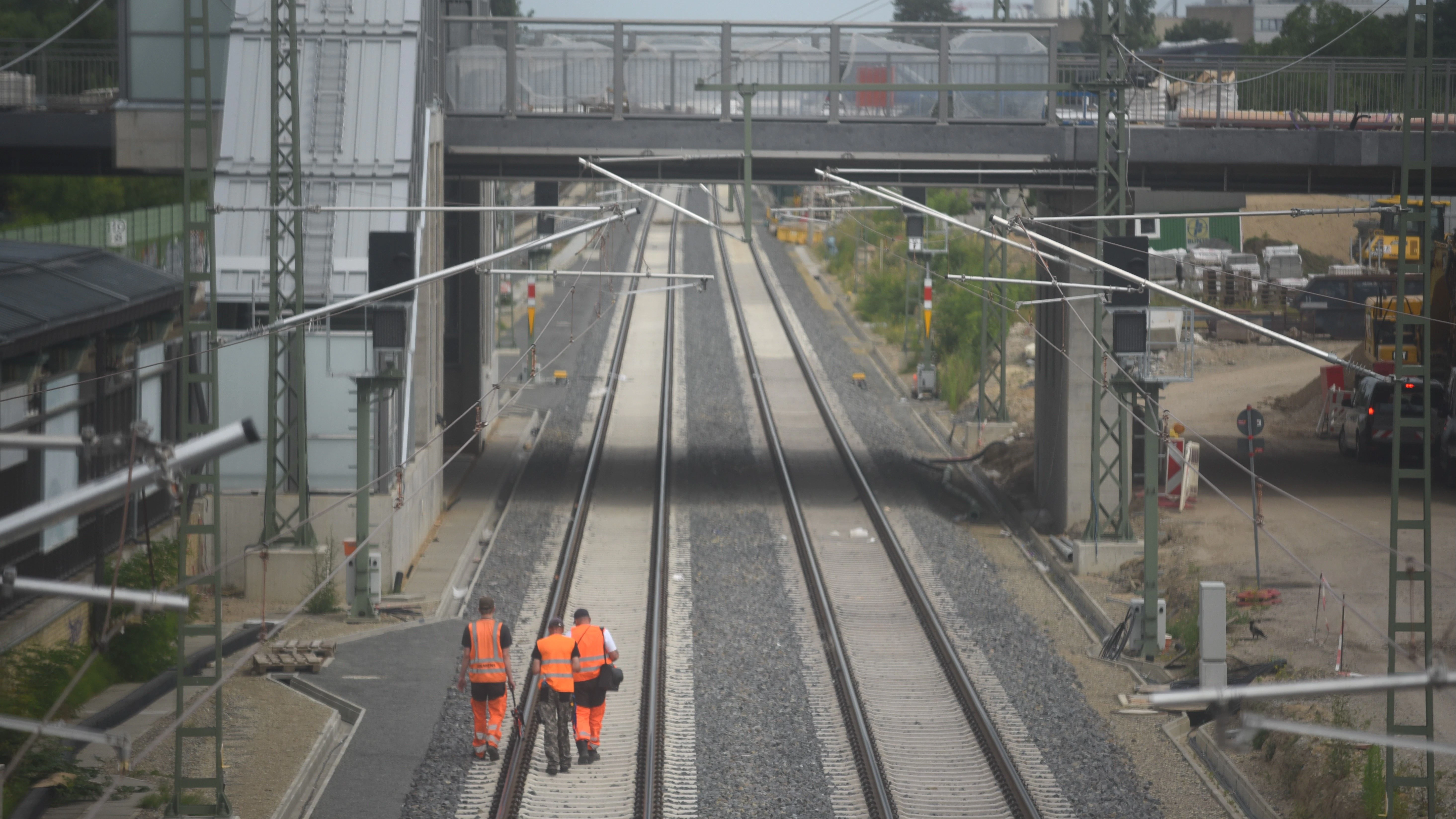 An der Überführung Buckower Chaussee: Bauarbeiter kontrollieren auf der neuerbauten Strecke der Dresdner Bahn die Gleise.