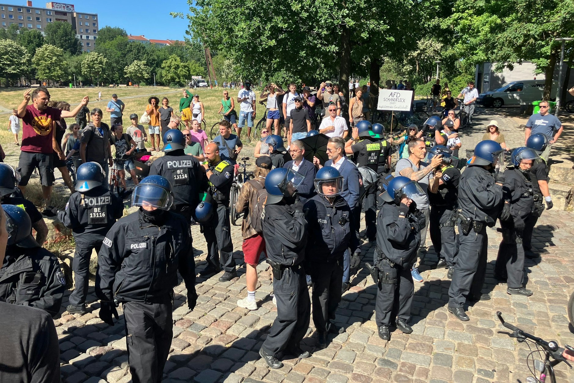 Ein Großaufgebot der Polizei trennt die AfD-Abgeordneten Alexander Bertram und Thorsten Weiß (beide im blauen Anzug) von den Demonstranten.