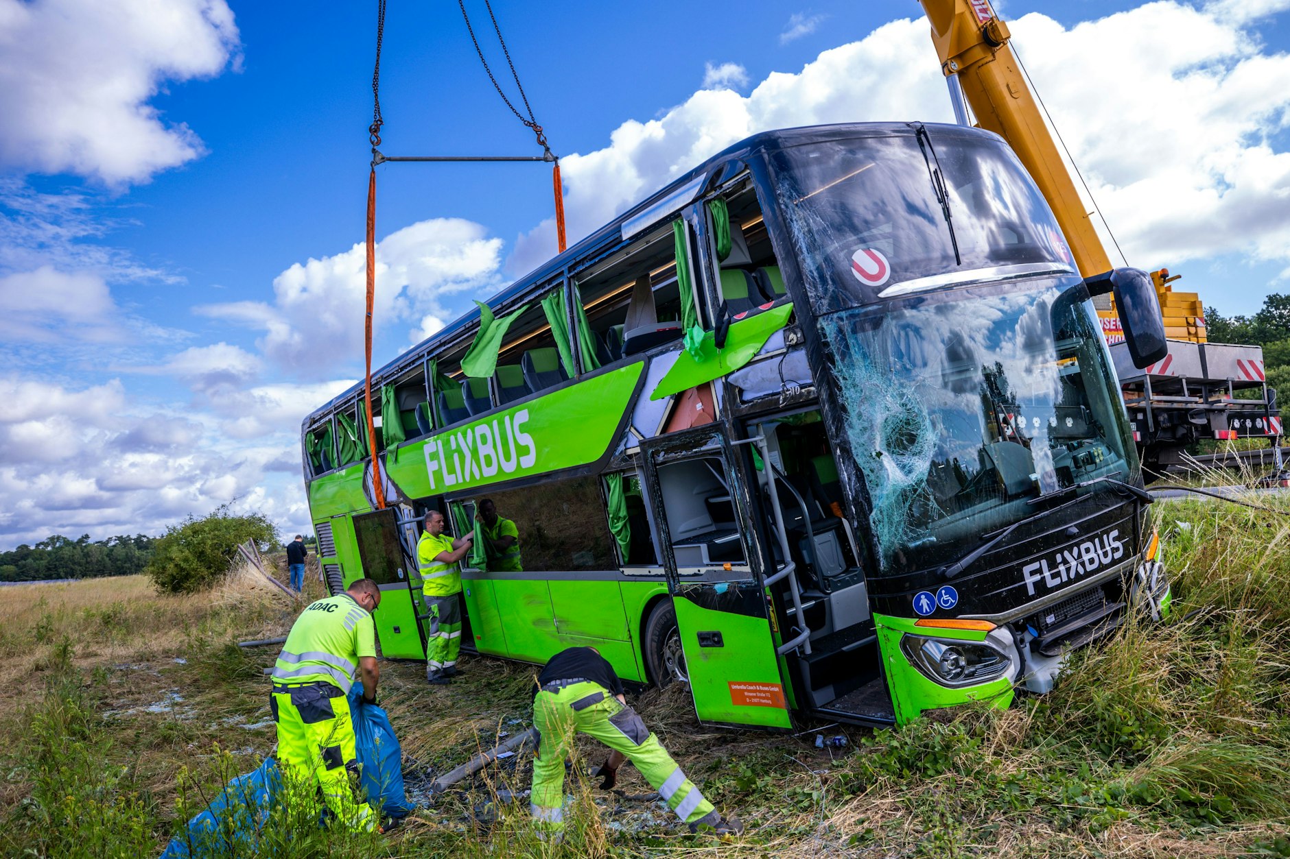 Bergungskräfte räumen die Unfallstelle. Ein Kran hat den umgekippten Bus an der A19 wieder aufgerichtet.