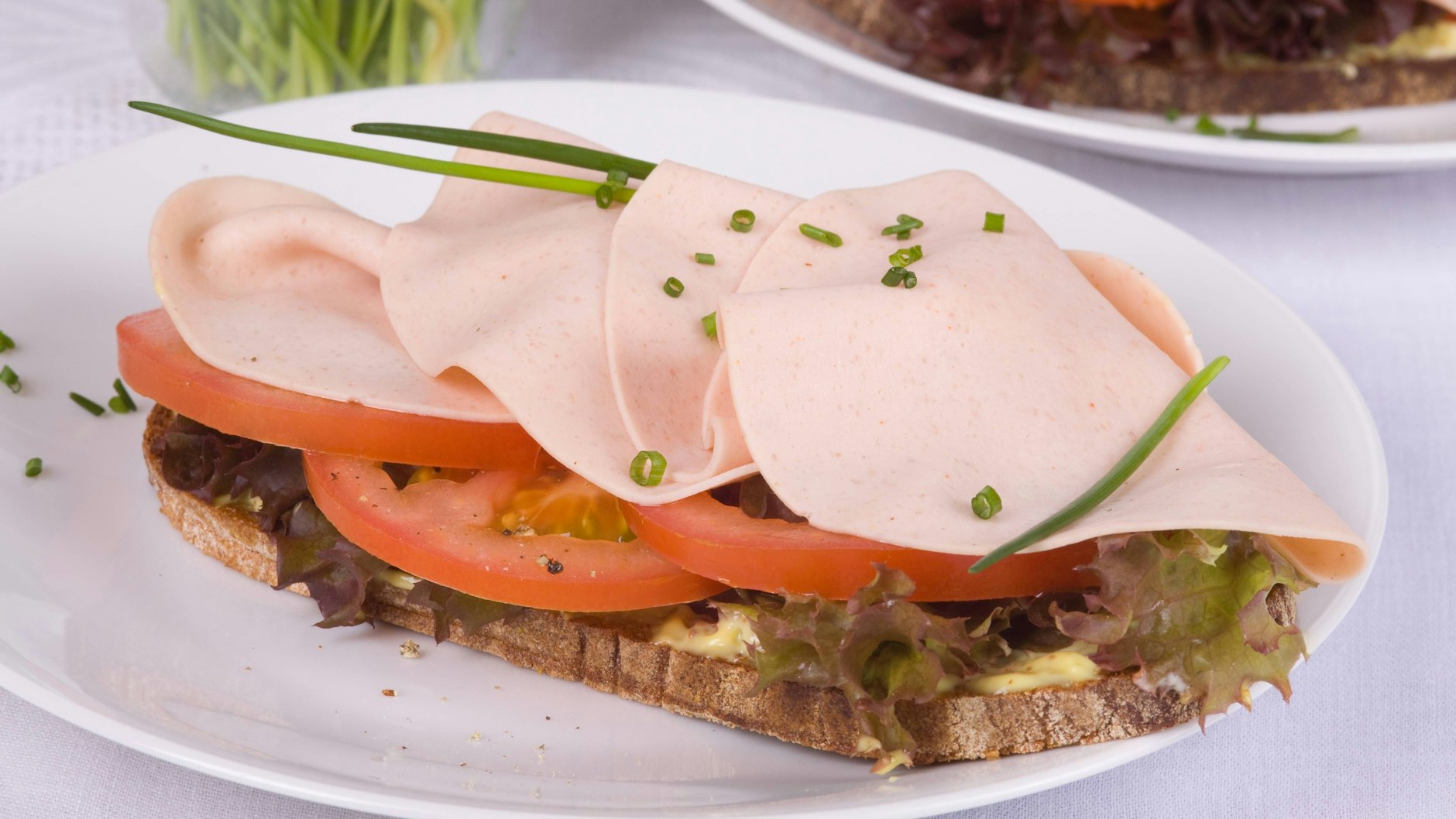 Das Brot kann auch mit anderer Wurst und anderen Garnituren angerichtet werden. Das, was die Stulle zur scharfen Sache aus der DDR macht, verbirgt sich hier unter der Wurst!