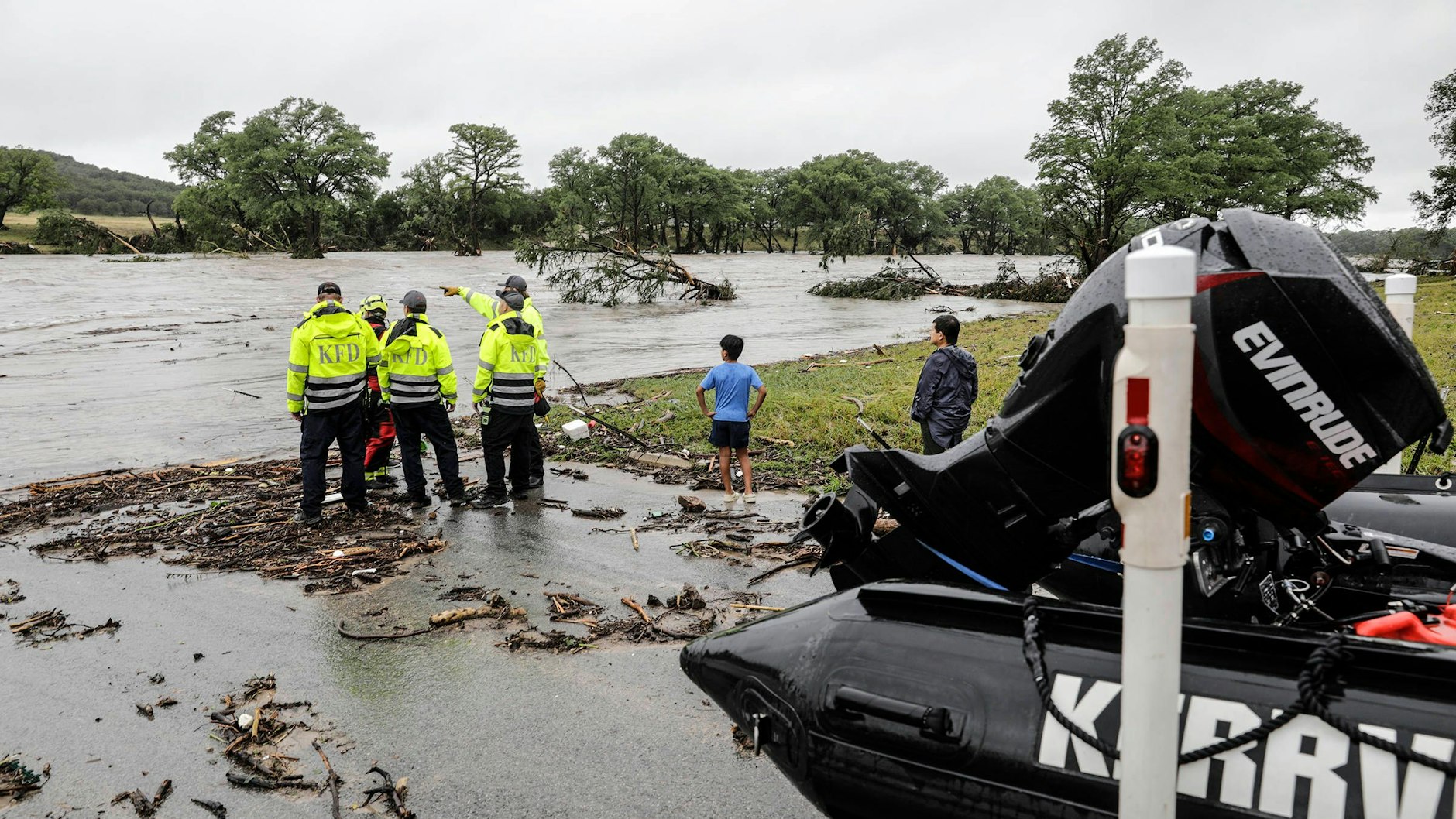 Helfer stehen am Ufer des Guadalupe River, beraten die nächsten Einsatzschritte.