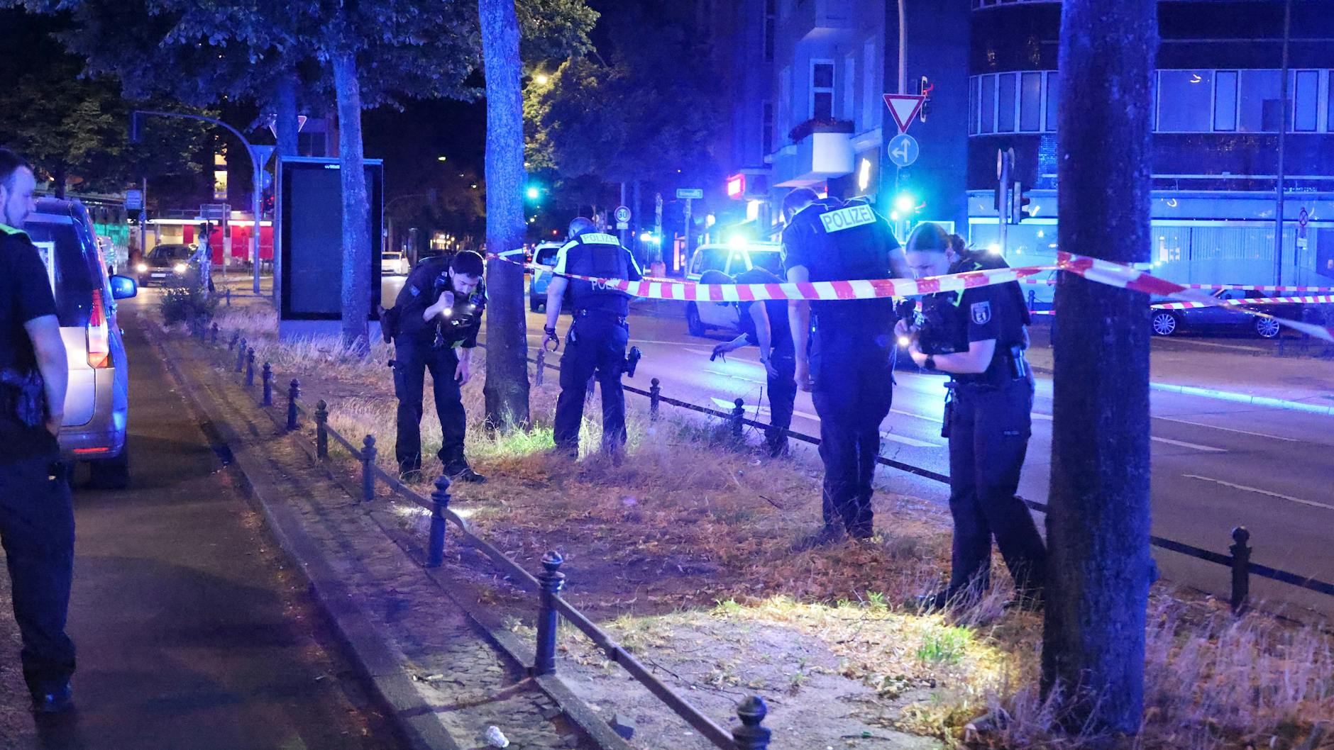 Polizisten untrersuchen deon Ort am Olivaer Platz, wo die angeschossene Person gefunden wurde.