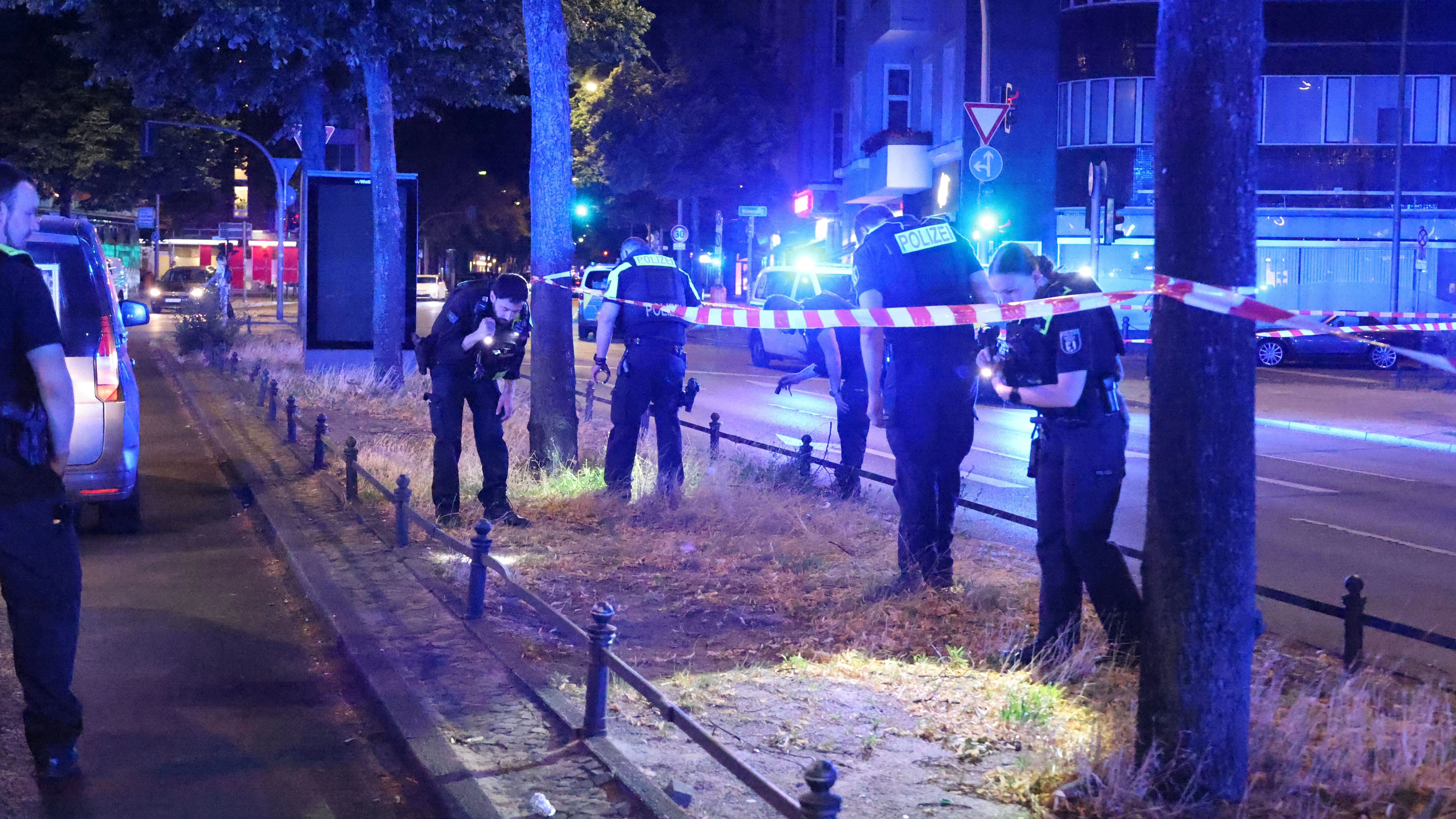 Polizisten untrersuchen deon Ort am Olivaer Platz, wo die angeschossene Person gefunden wurde.