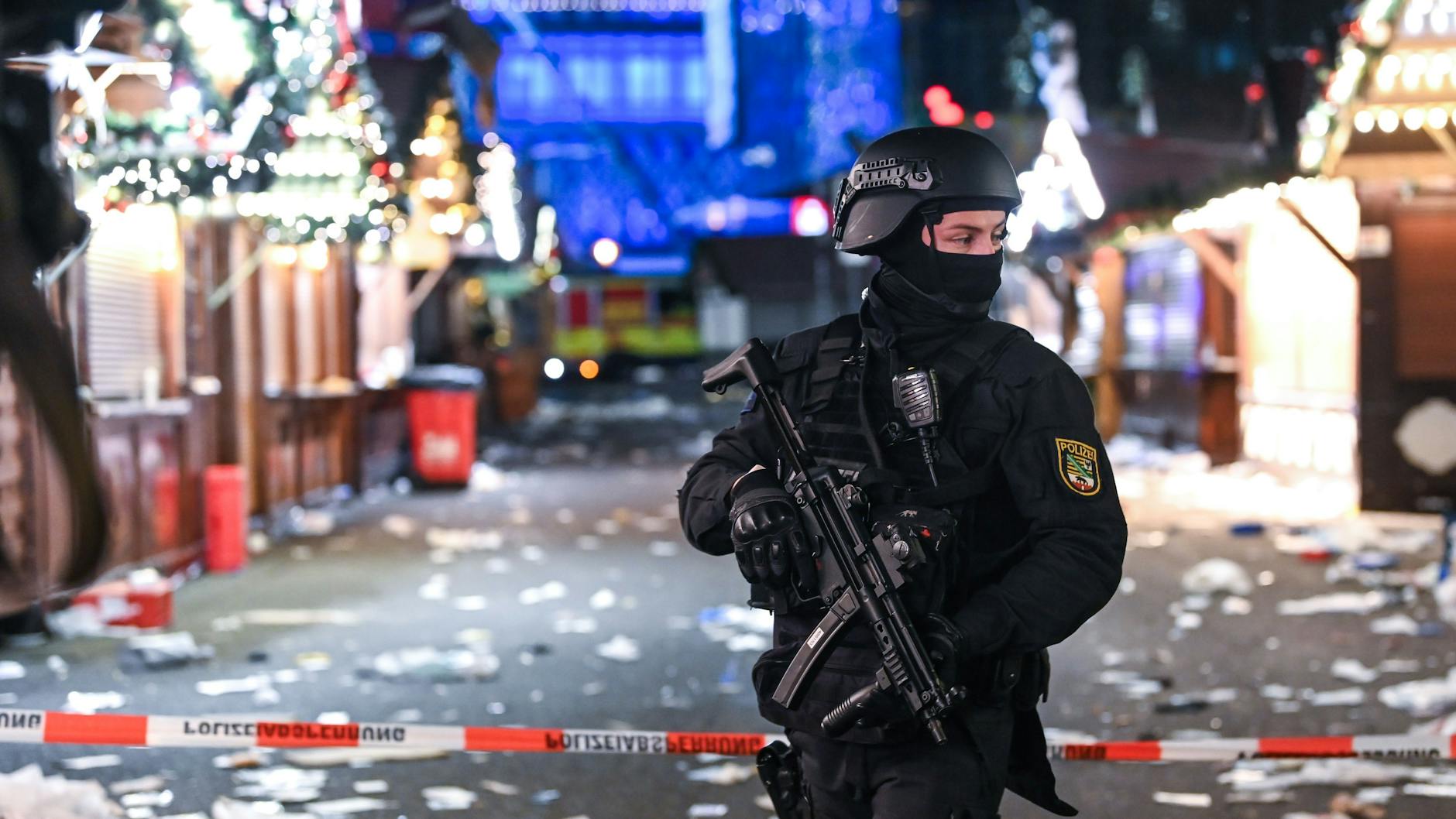 Dezember 2024: Ein bewaffneter Polizist steht vor dem verwüsteten Weihnachtsmarkt in Magdeburg. Taleb A. war dort mit dem Auto hineingerast, sechs Menschen starben.