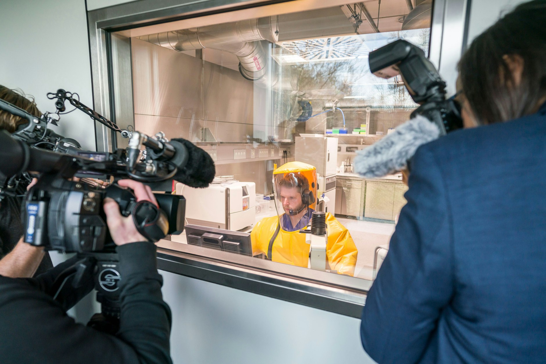 Journalists film an employee working on organisms in a high-security laboratory at the Institute of Virology at Philipps University Marburg. Marburg researchers were involved in the development of a vaccine against the coronavirus.