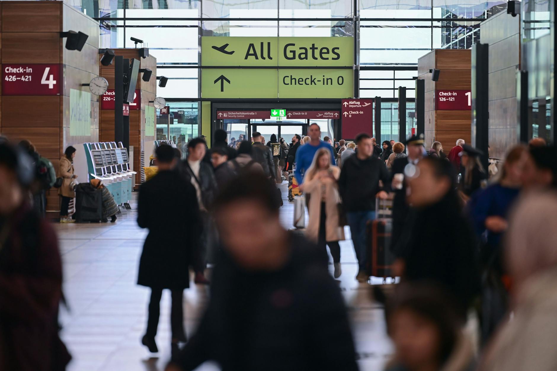 Reisende gehen am Flughafen BER durch das Terminal 1.