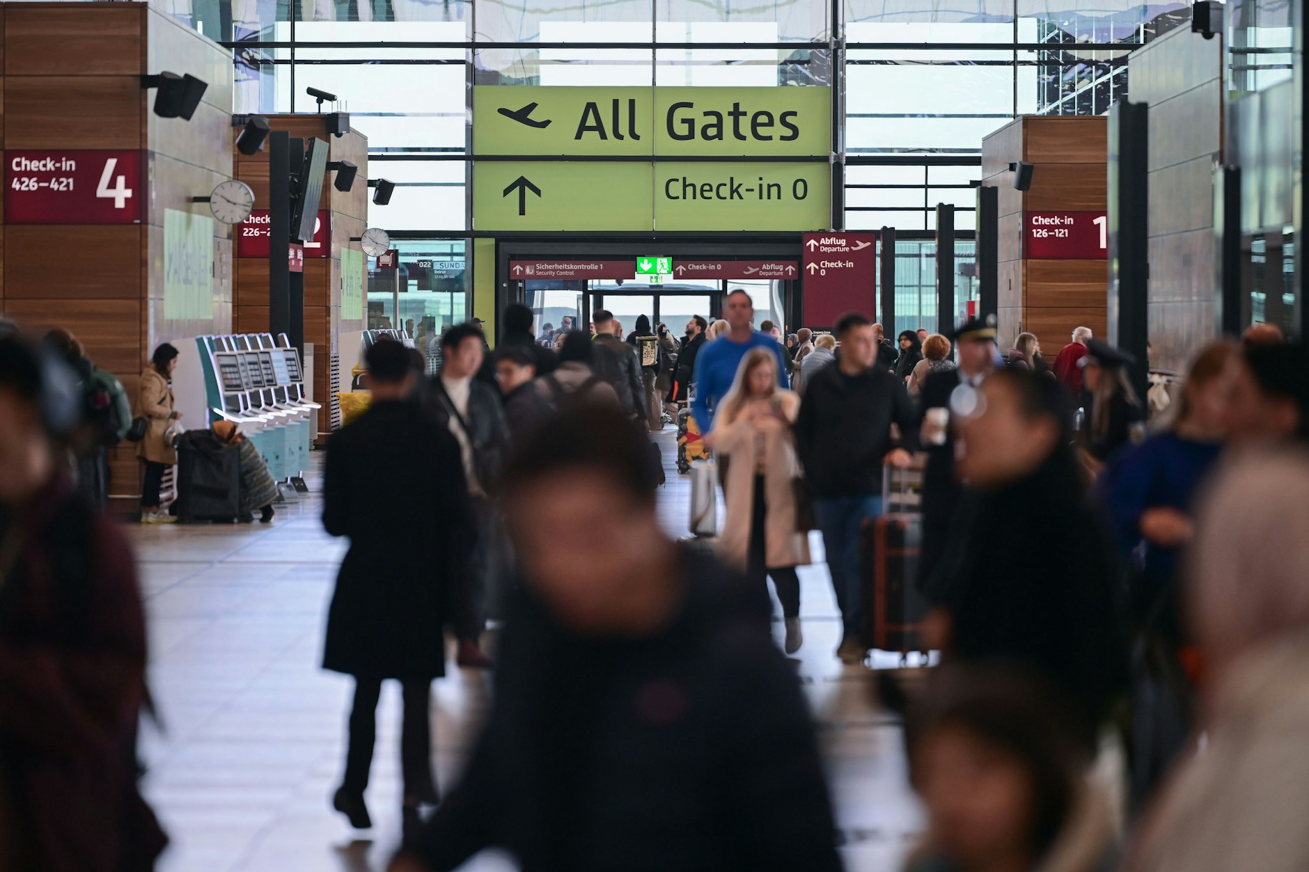 Reisende gehen am Flughafen BER durch das Terminal 1.