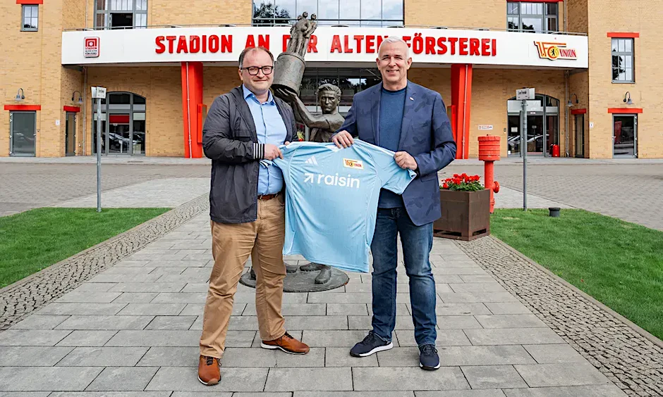 Union-Präsident Dirk Zingler (rechts) und Raisin-CEO Tamaz Georgadze präsentieren vor der Alten Försterei das neue himmelblaue Auswärtstrikot mit dem Raisin-Aufdruck.