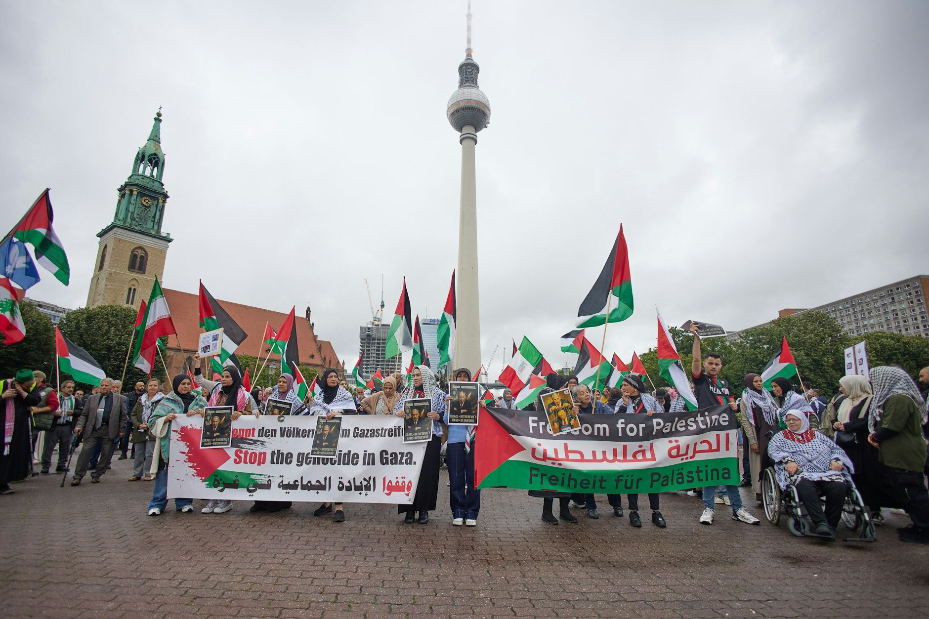 Menschen nehmen an einer propalästinensischen Kundgebung unter dem Motto «Solidarität mit Palästina - Stoppt den Gaza Genozid» am Neptunbrunnen vor dem Fernsehturm teil.