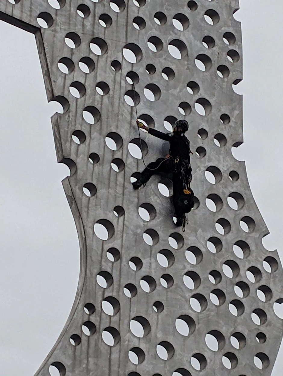 Einsatz am berühmten „Molecule Men“: Polizisten mussten auf die Skulptur klettern, um das Transparent wieder zu entfernen.