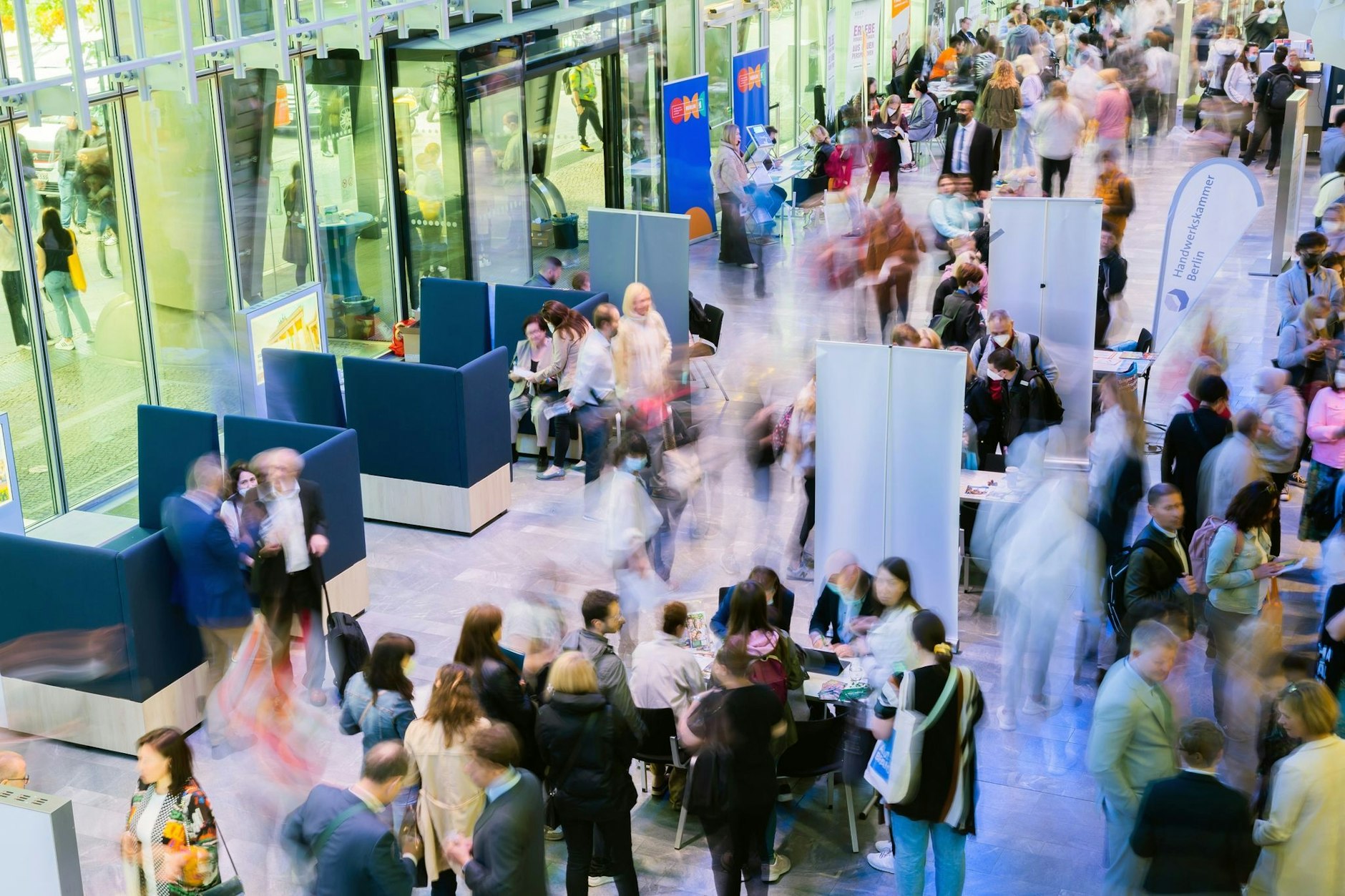 Teilnehmer einer Jobmesse für ukrainische Geflüchtete besuchen Infostände.